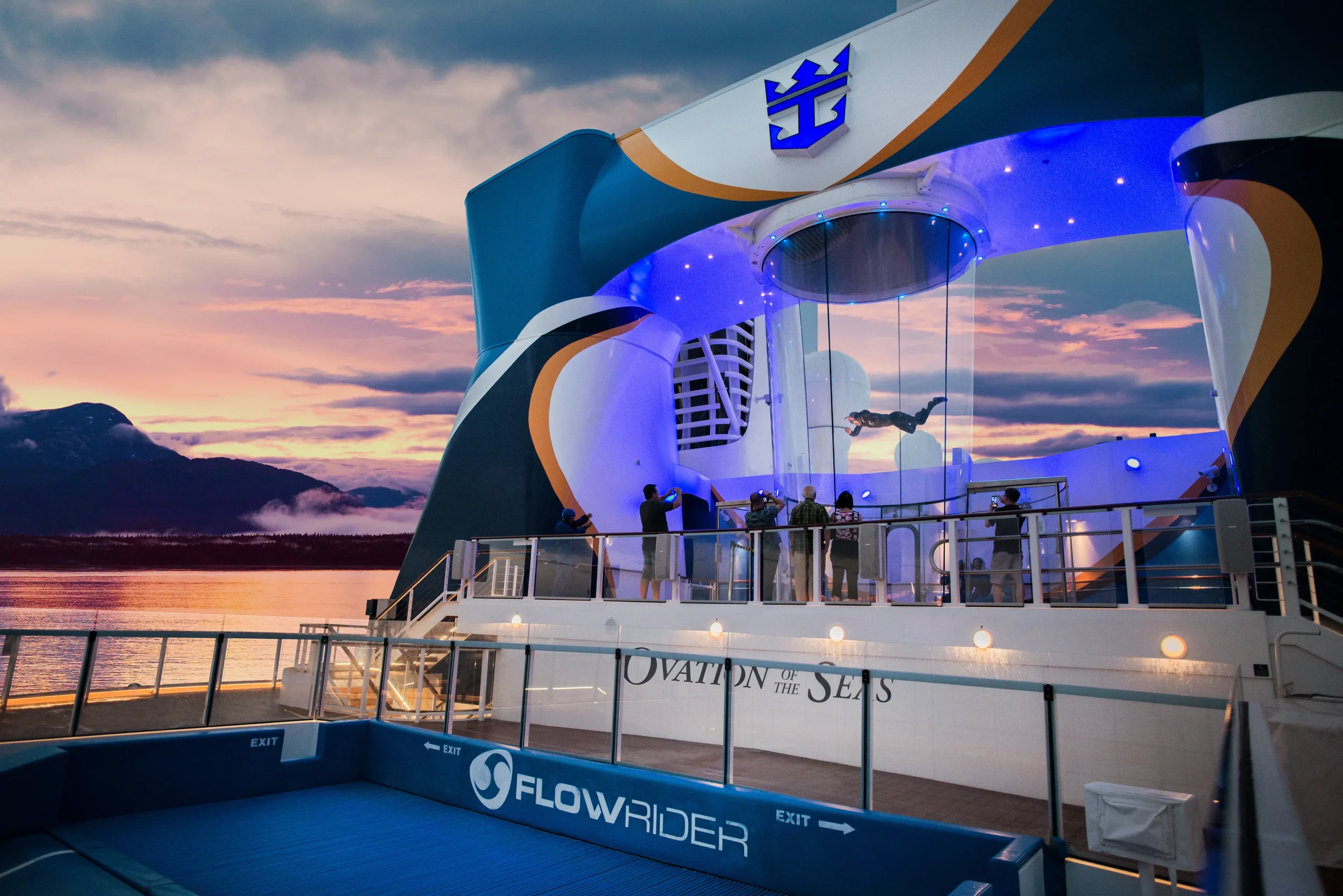 RipCord by iFly skydiving simulator aboard Ovation of the Seas at sunset, with Alaska mountains in the background on Royal Caribbean’s Quantum Class ship.
