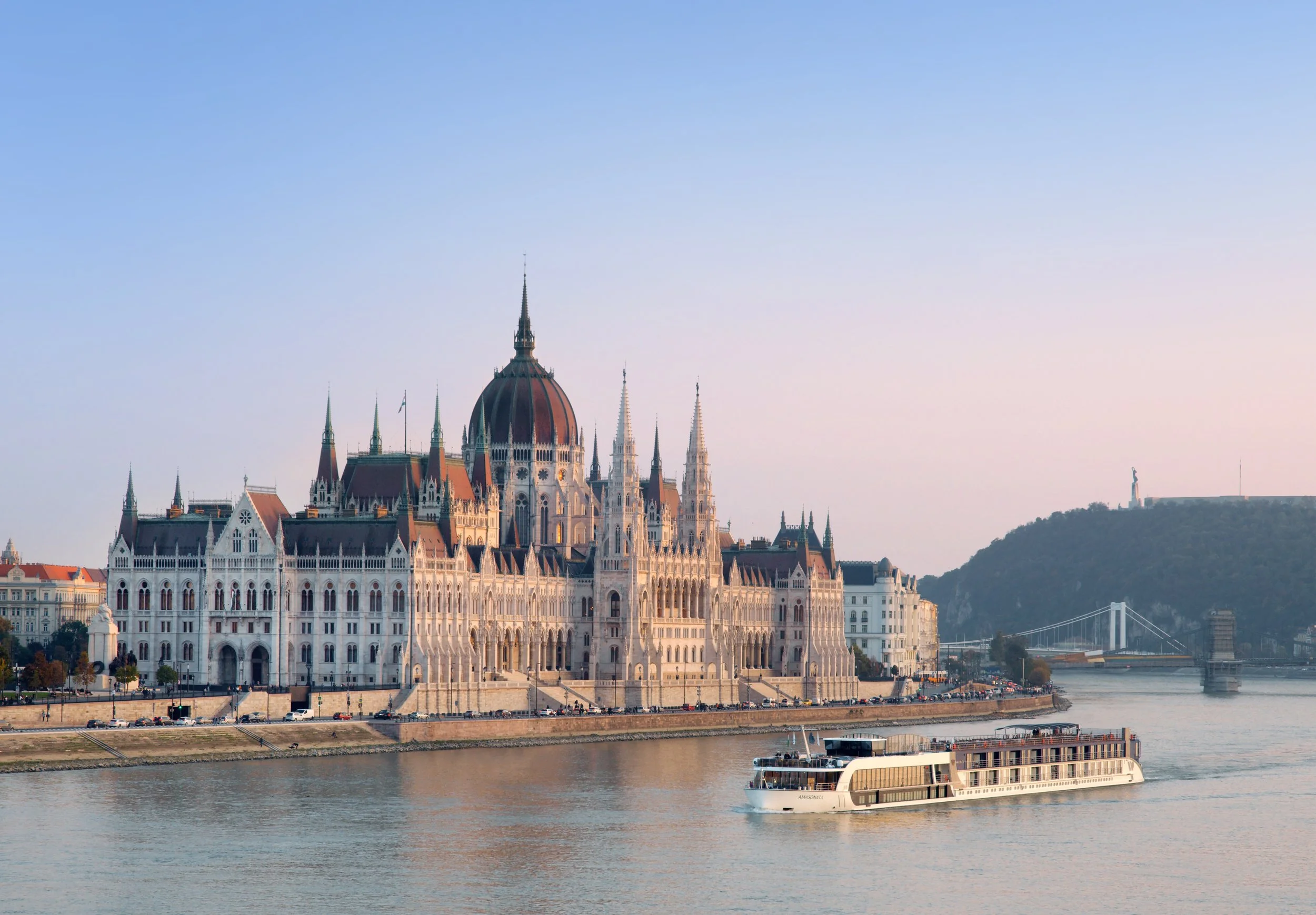 AmaSonata river cruise ship on the Danube River in Budapest, passing the Hungarian Parliament Building
