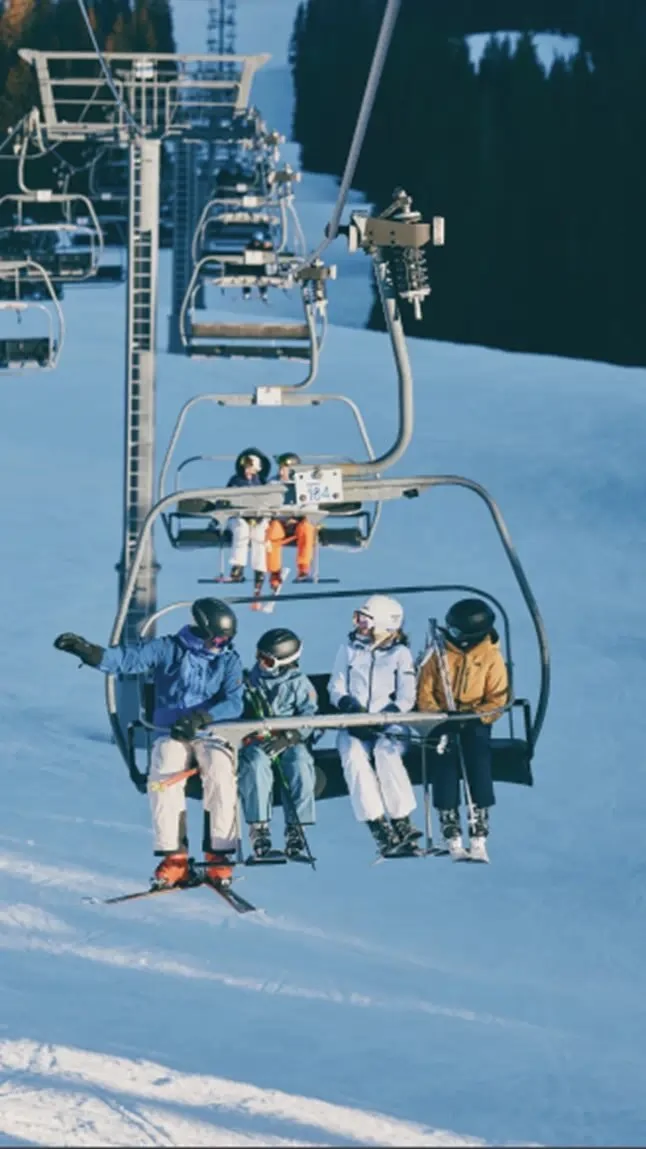 Skiers riding a chairlift at Aspen Snowmass ski resort