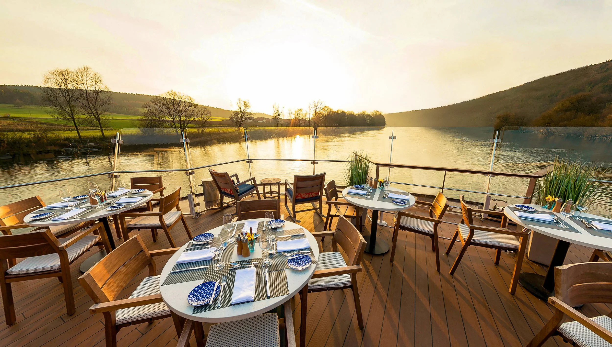 Viking River Cruises ship outdoor dining terrace with river views during sunset