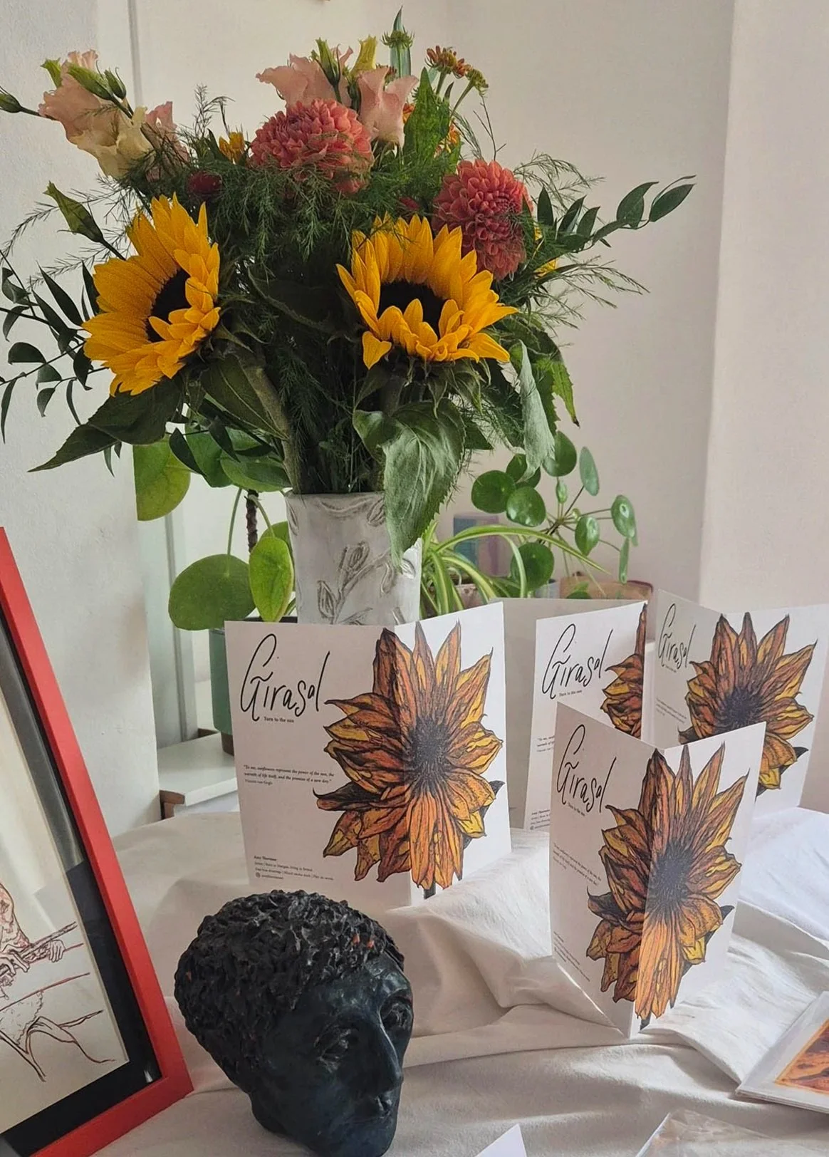 A picture of the sunflower cards on a table with a vase of flowers