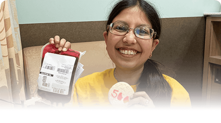 Yasmeen is holding a blood bag before she receives a transfusion.