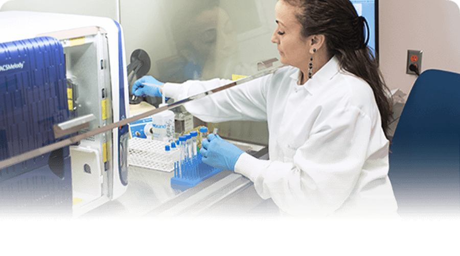 A researcher loads samples into a machine before testing.