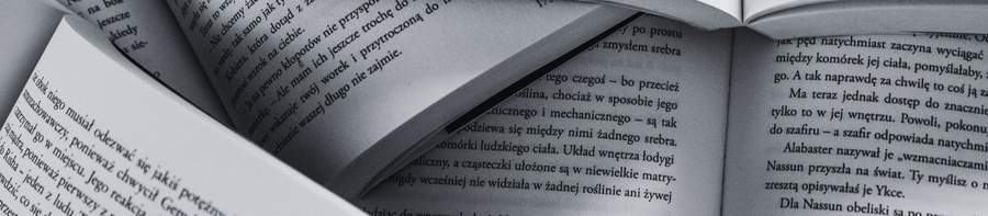 Close-up of an open book with pages turned, showing text in a language that appears to be Polish.