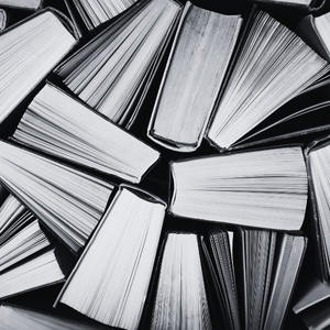 A pile of open books with pages facing up, arranged haphazardly.