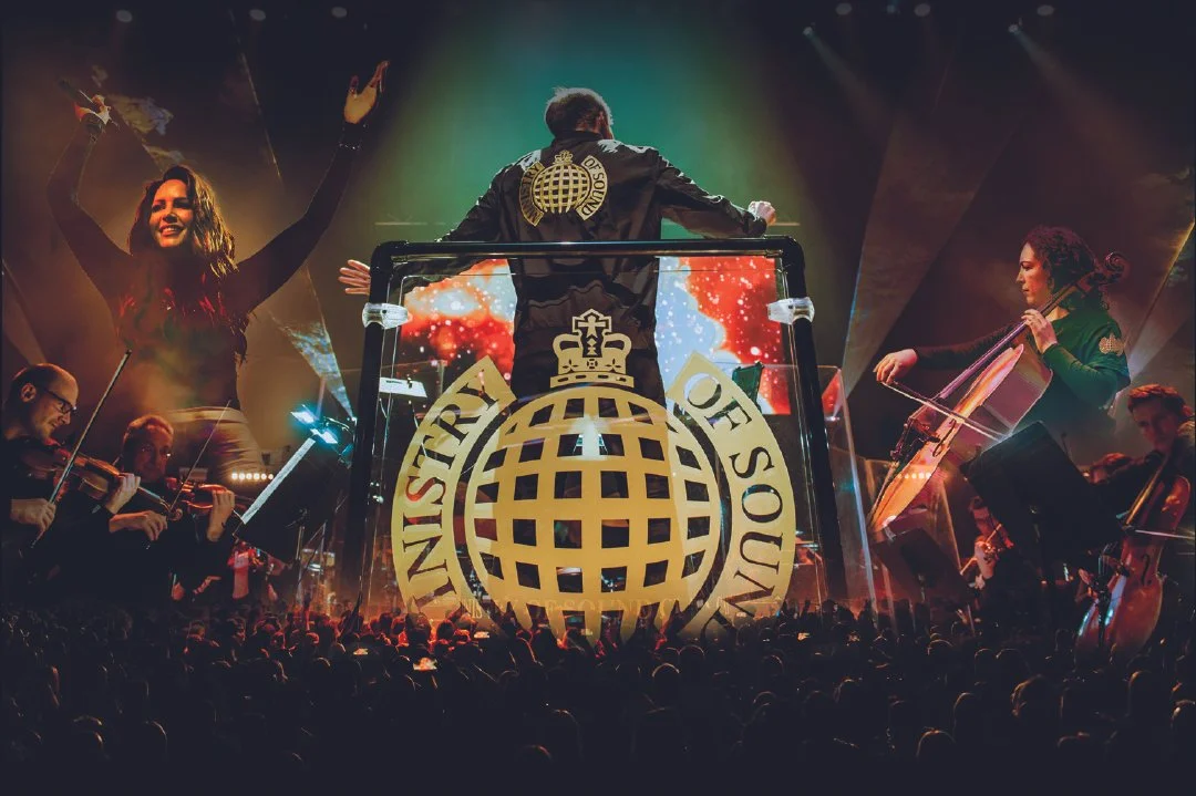 Concert scene with a conductor and musicians, with a large