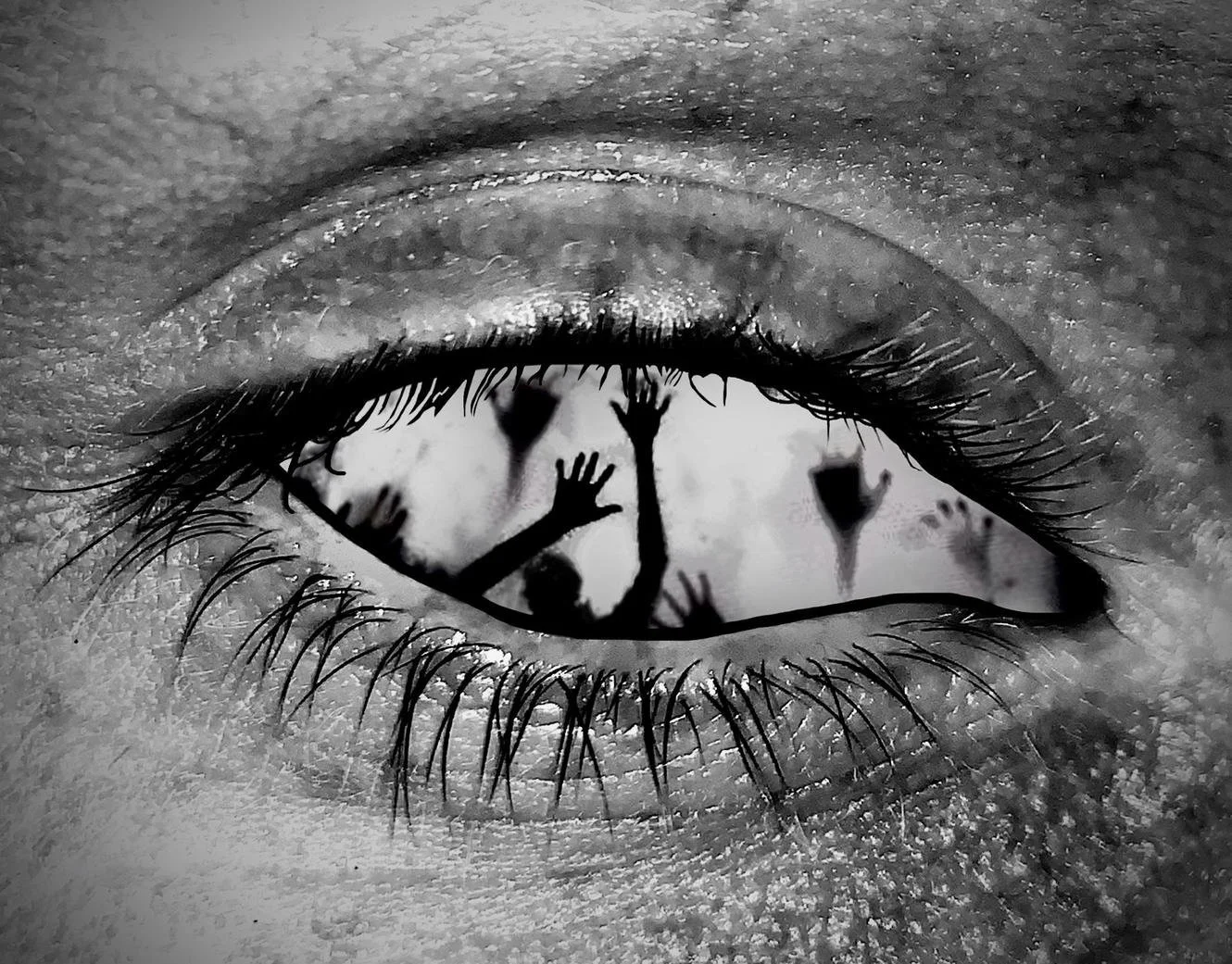 Close-up of a human eye in black and white, with silhouettes of people reaching and raising their hands reflected in the iris.