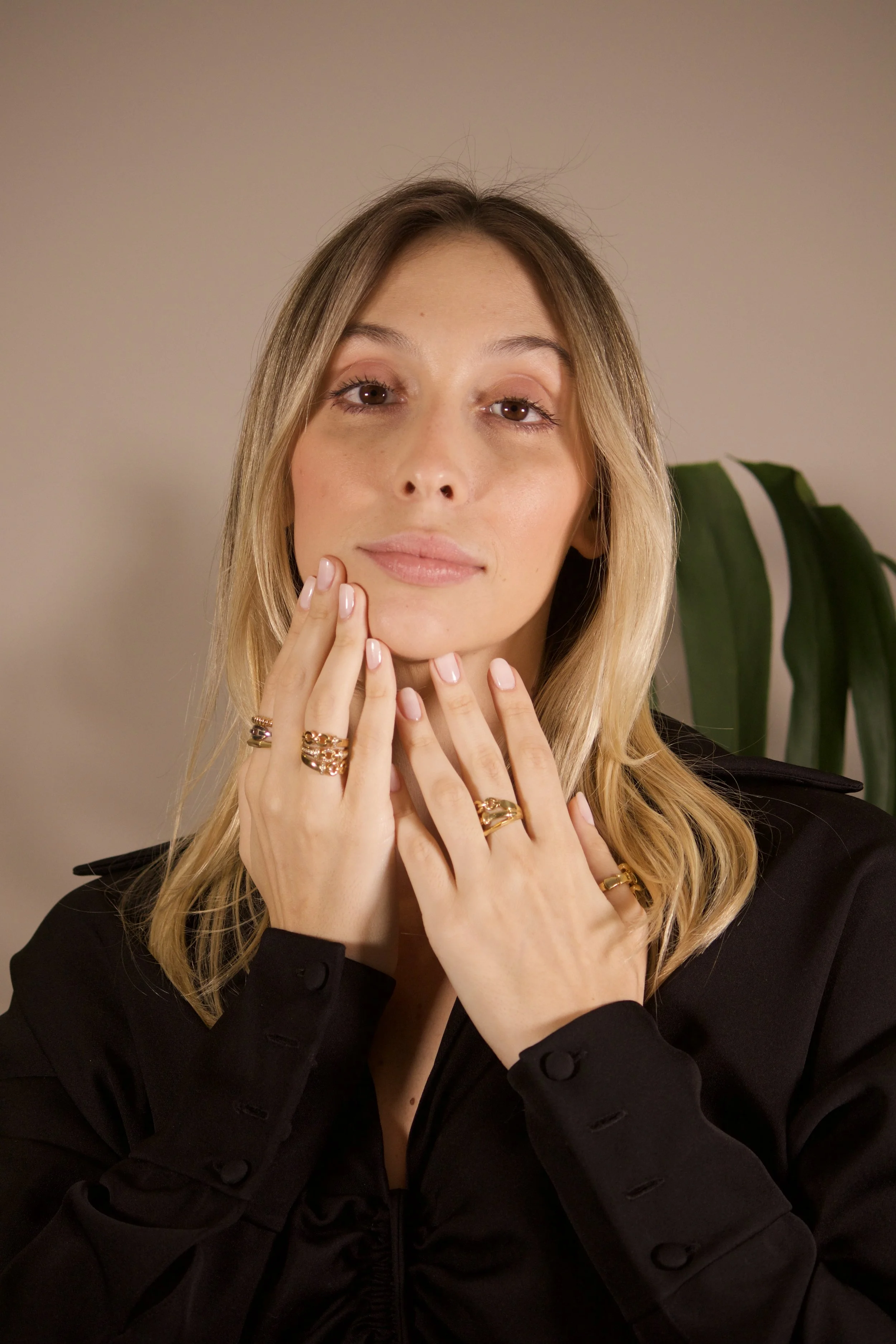 Mujer luciendo anillos y joyas de oro Dioro en un estilo sofisticado.