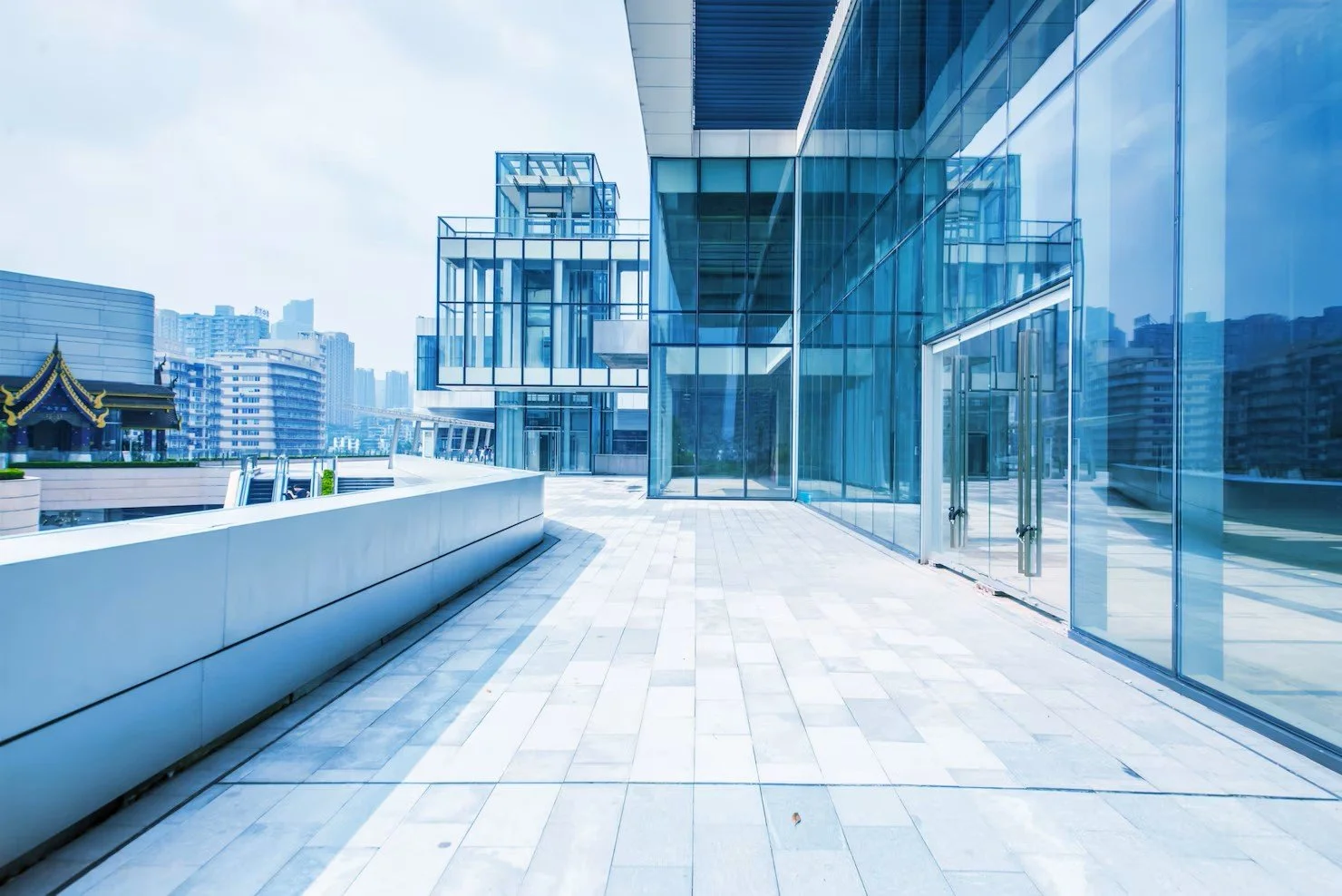 Empty modern glass building terrace with city skyline in the background