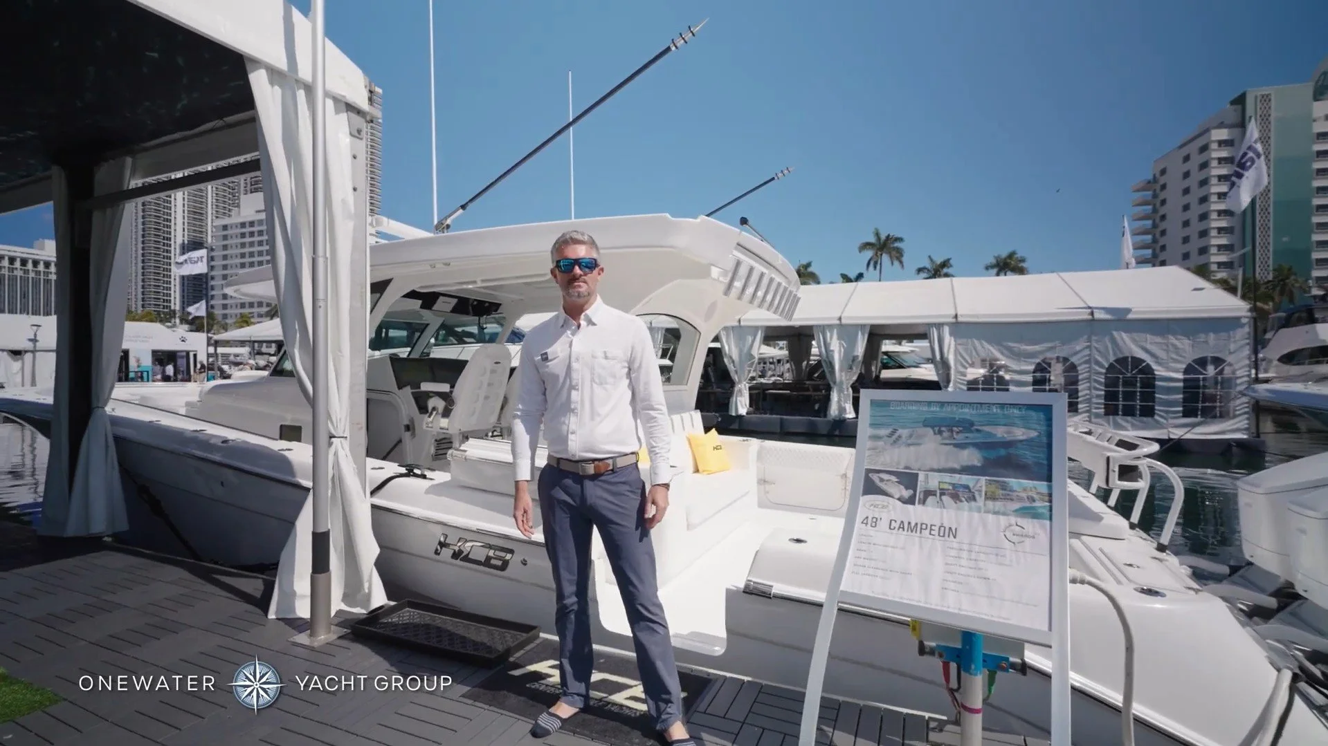 Yacht Broker Kiefer Woods on the docks at the Miami International Boat Show in front of an HCB center console boat