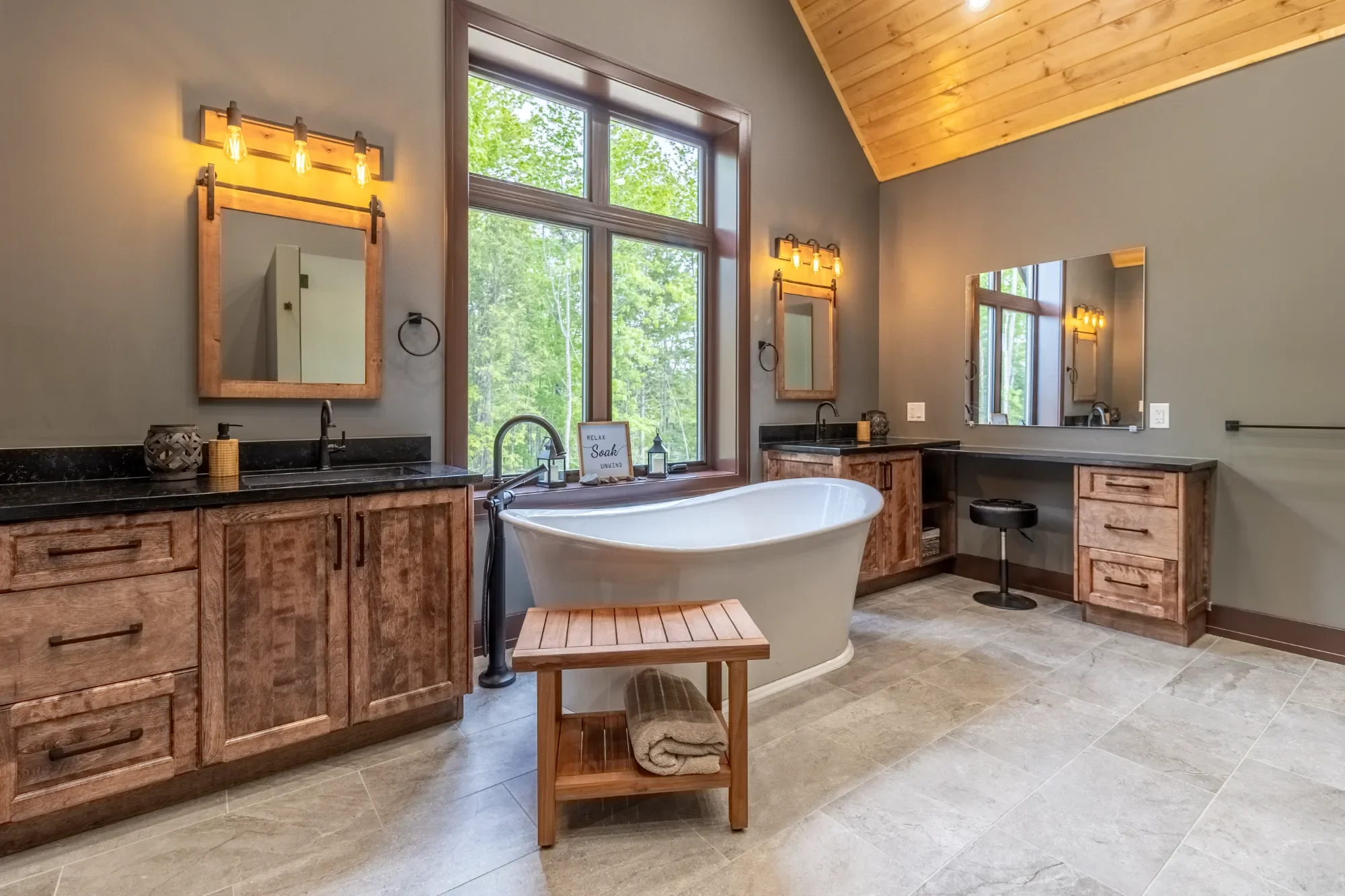 Bathroom with double vanity, large window, and standalone bathtub.