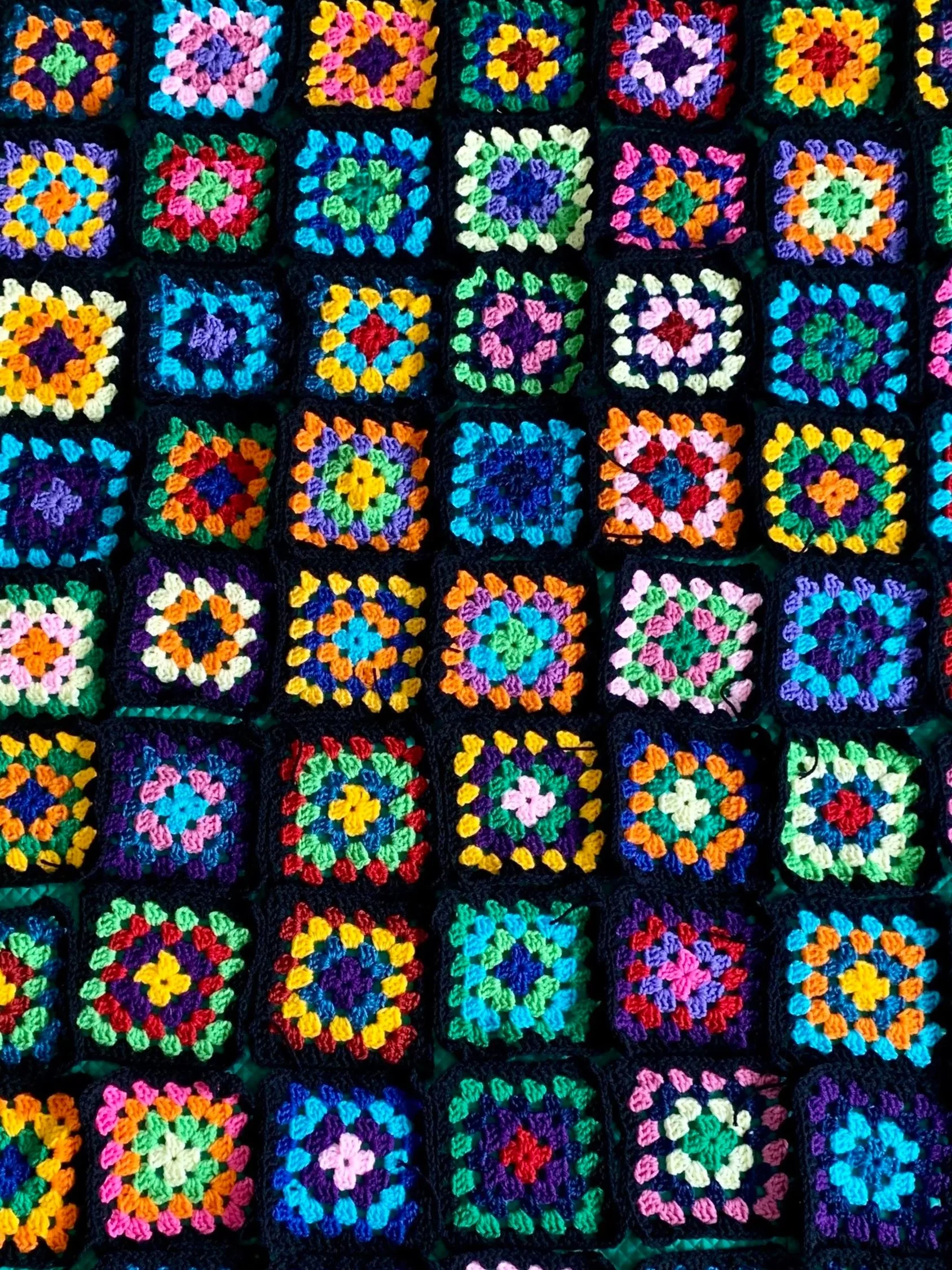 Colorful crochet granny squares arranged in a grid pattern.