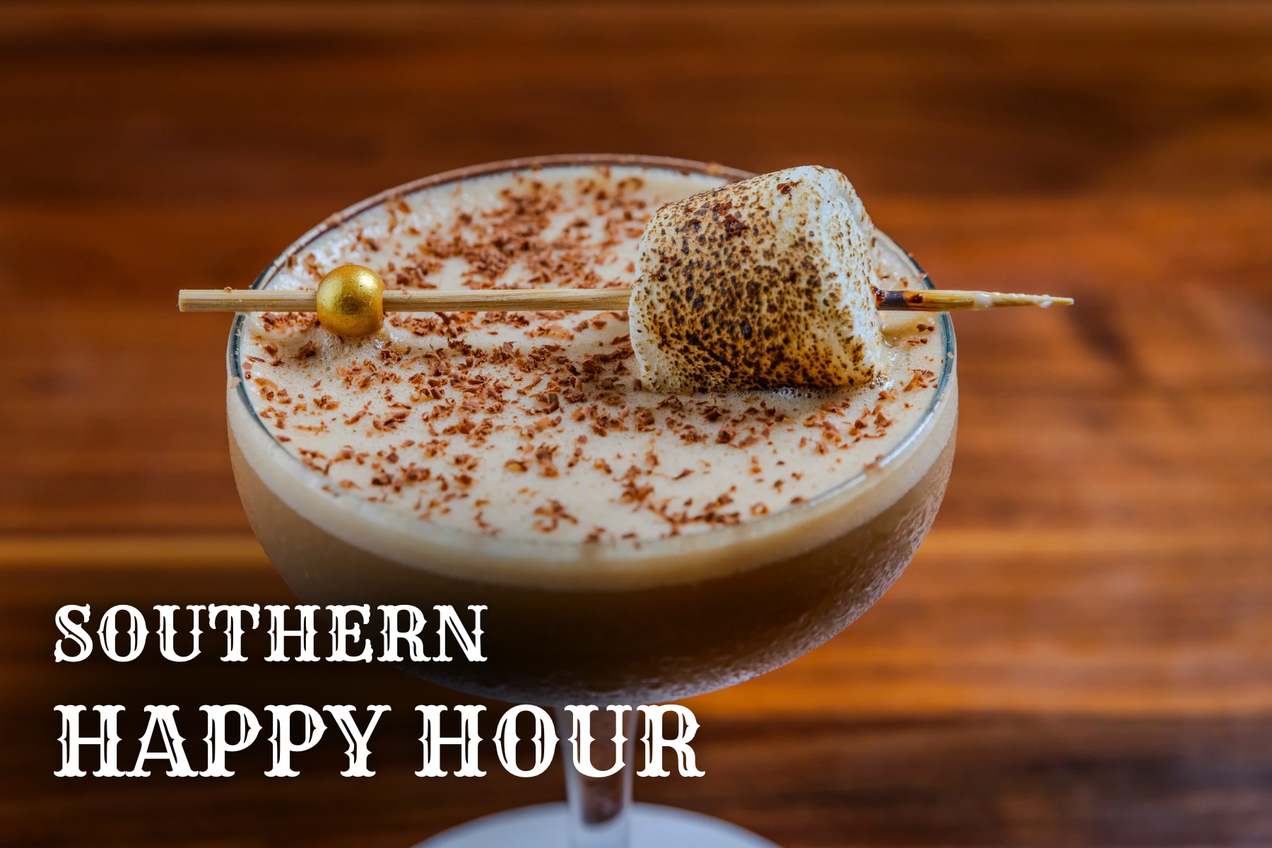 Close-up of a creamy cocktail garnished with a toasted marshmallow on a skewer. White text reads ‘Southern Happy Hour.
