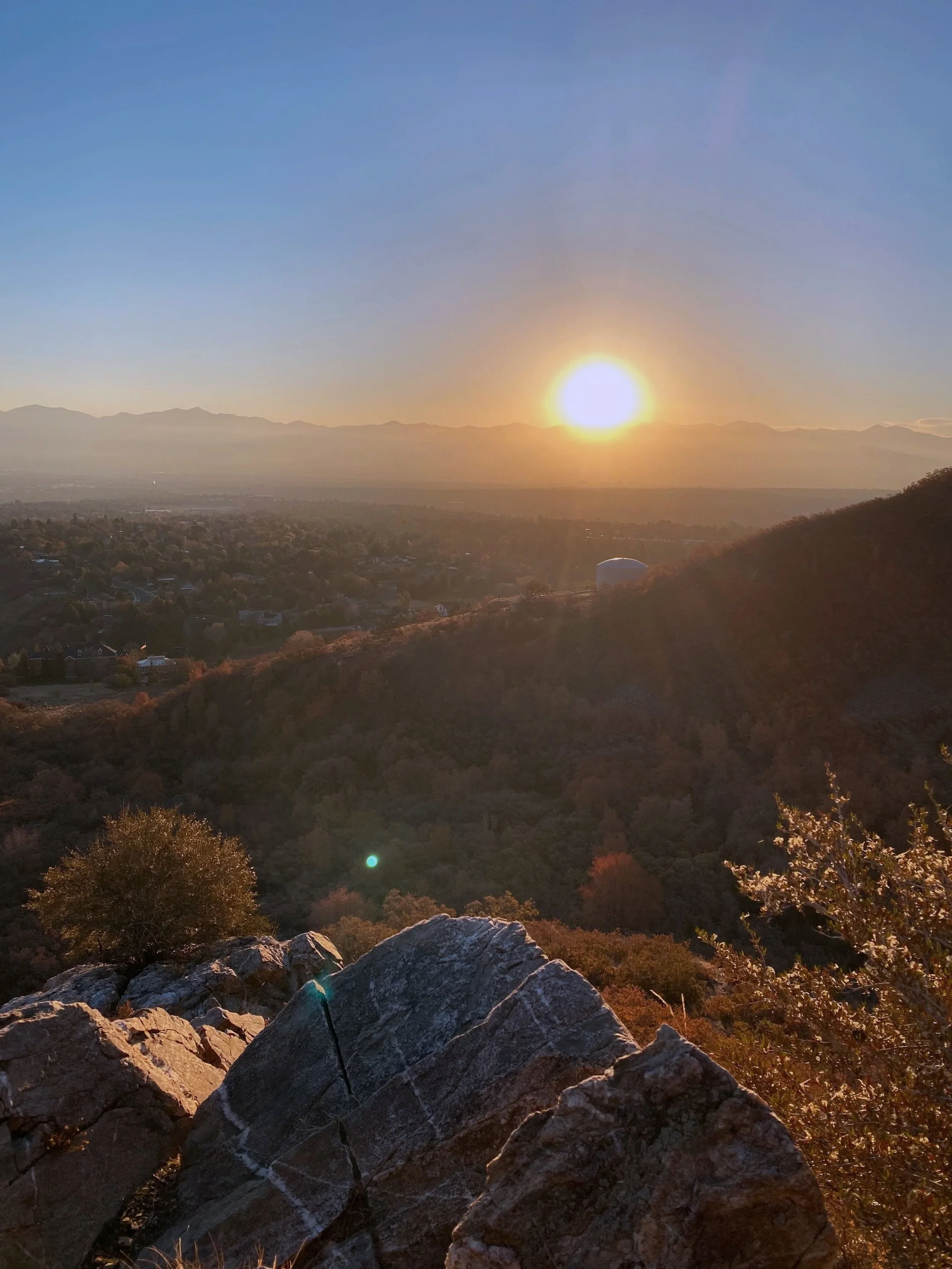 A photo of the sun over the mountains in Utah - taken by V on a hike