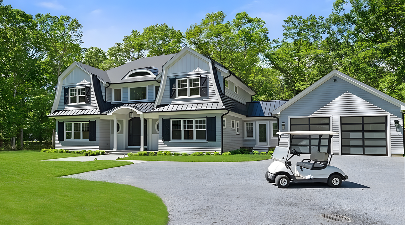 Large modern house with a distinctive roof design, surrounded by green trees and a well-maintained lawn, with a white golf cart parked in the driveway.