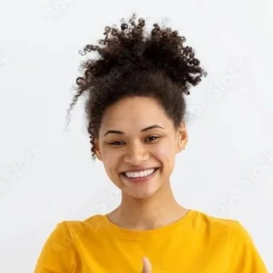 A woman with curly hair styled in an updo, smiling, wearing a yellow shirt on a white background.