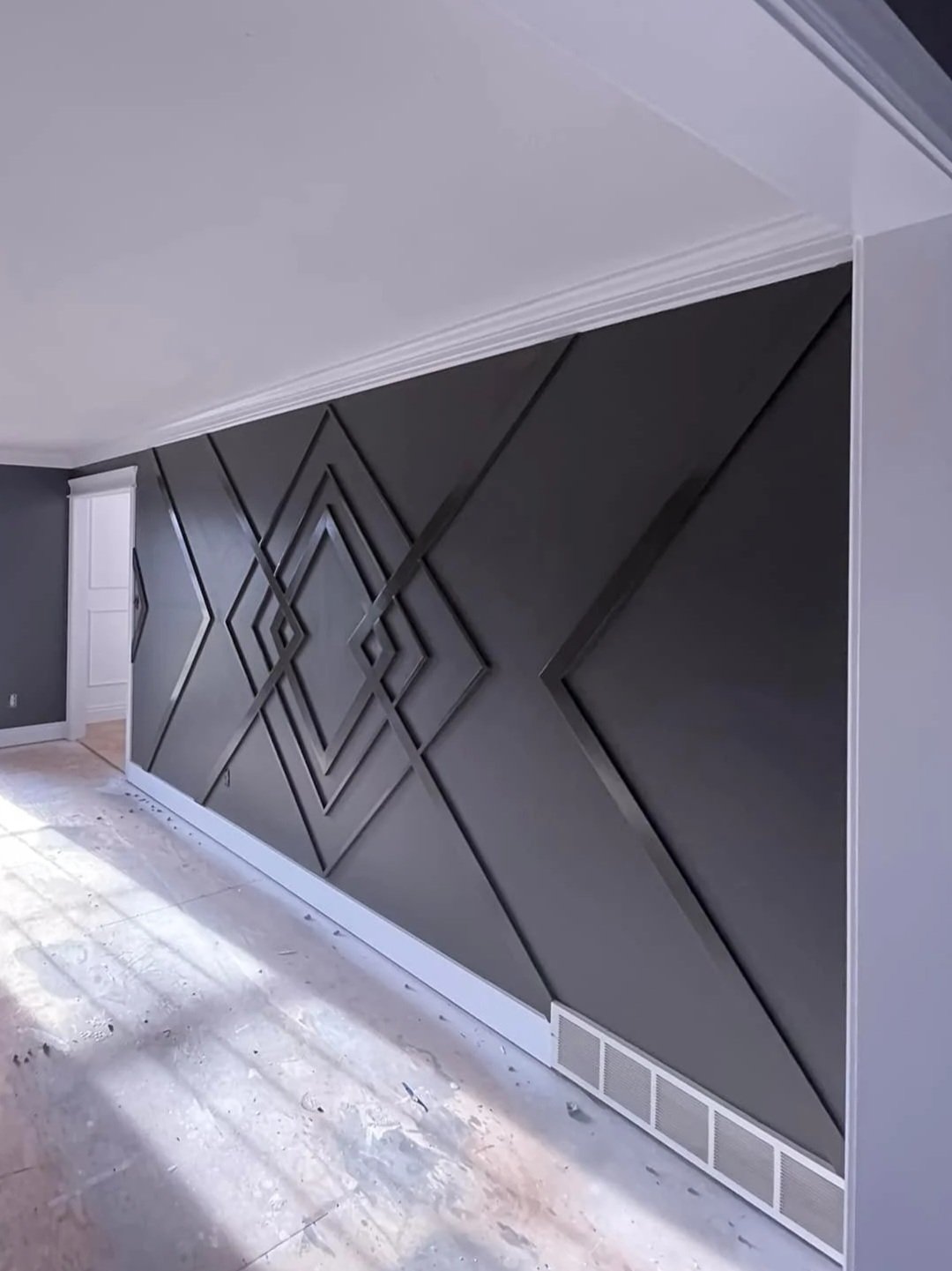 Interior wall with decorative black 3D geometric wall panels in a modern living space.