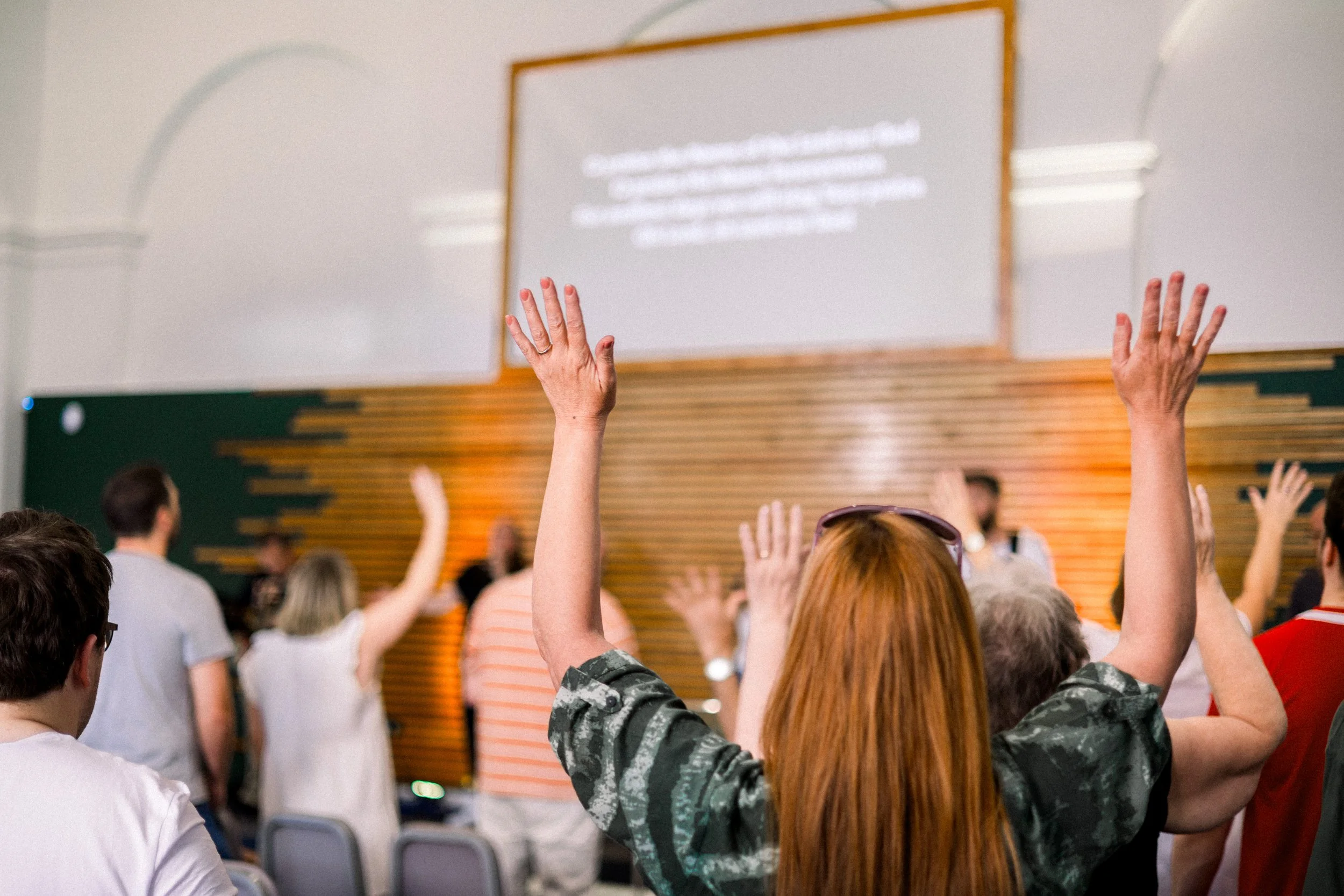 Woman with hands raised in Worship facing forwards