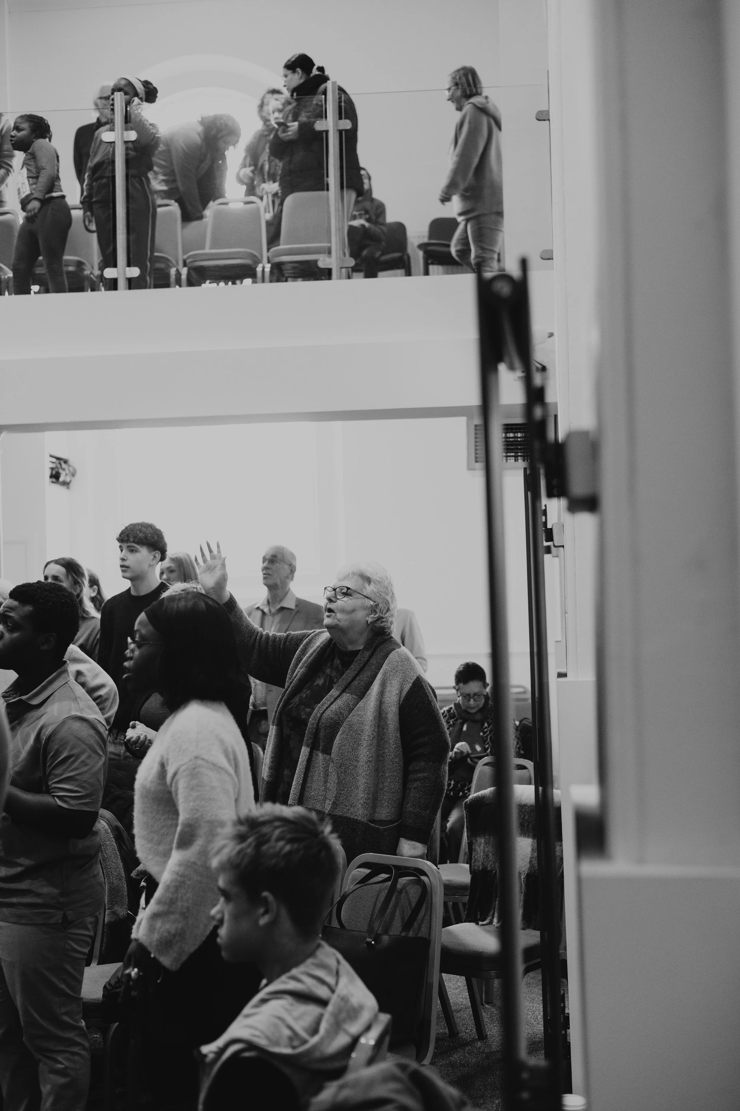 image of congregation worshipping, specifically a lady with hand raised