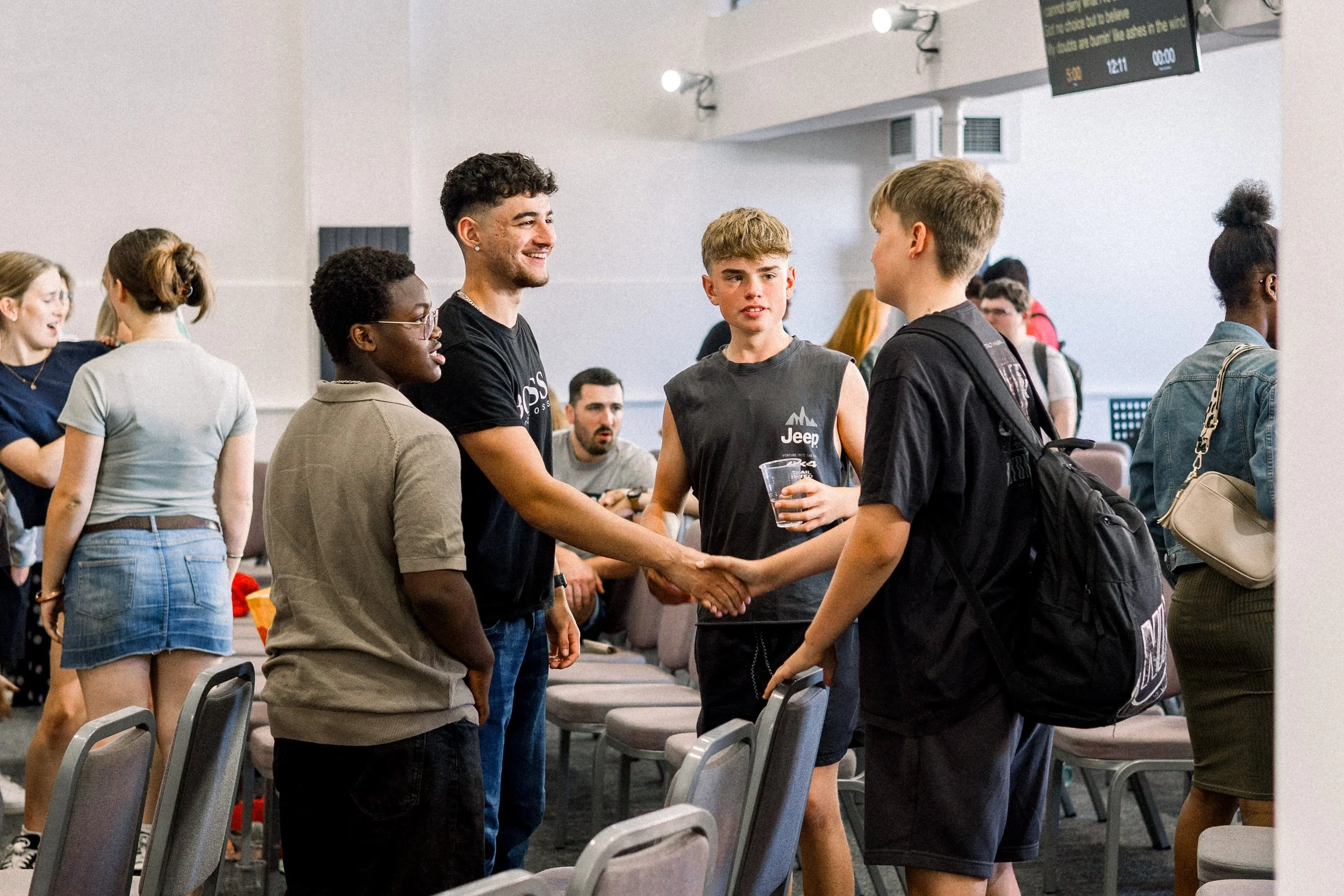 Group of young people smiling and shaking hands at church