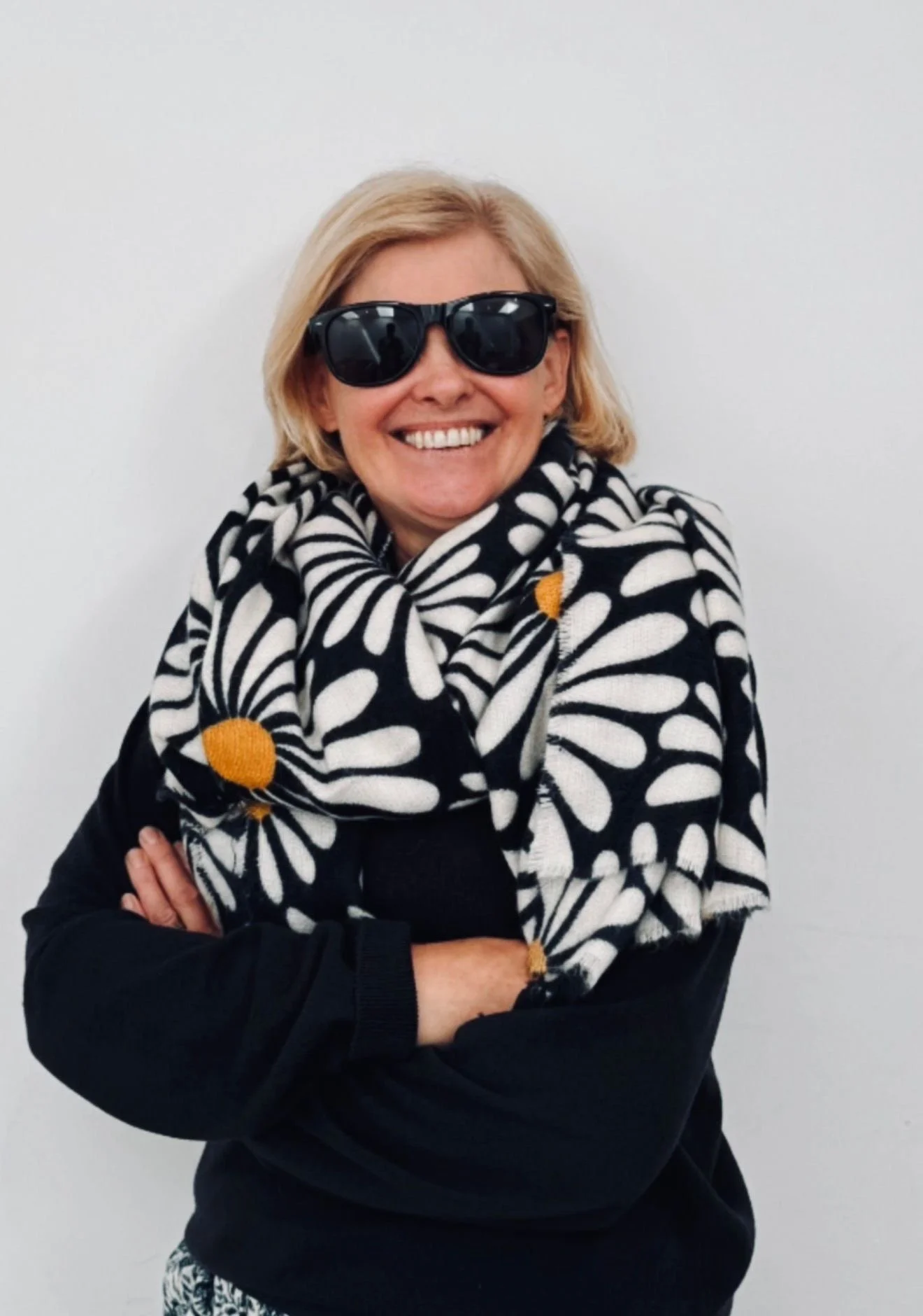 Carolyn with her arms folded and large sunglasses on