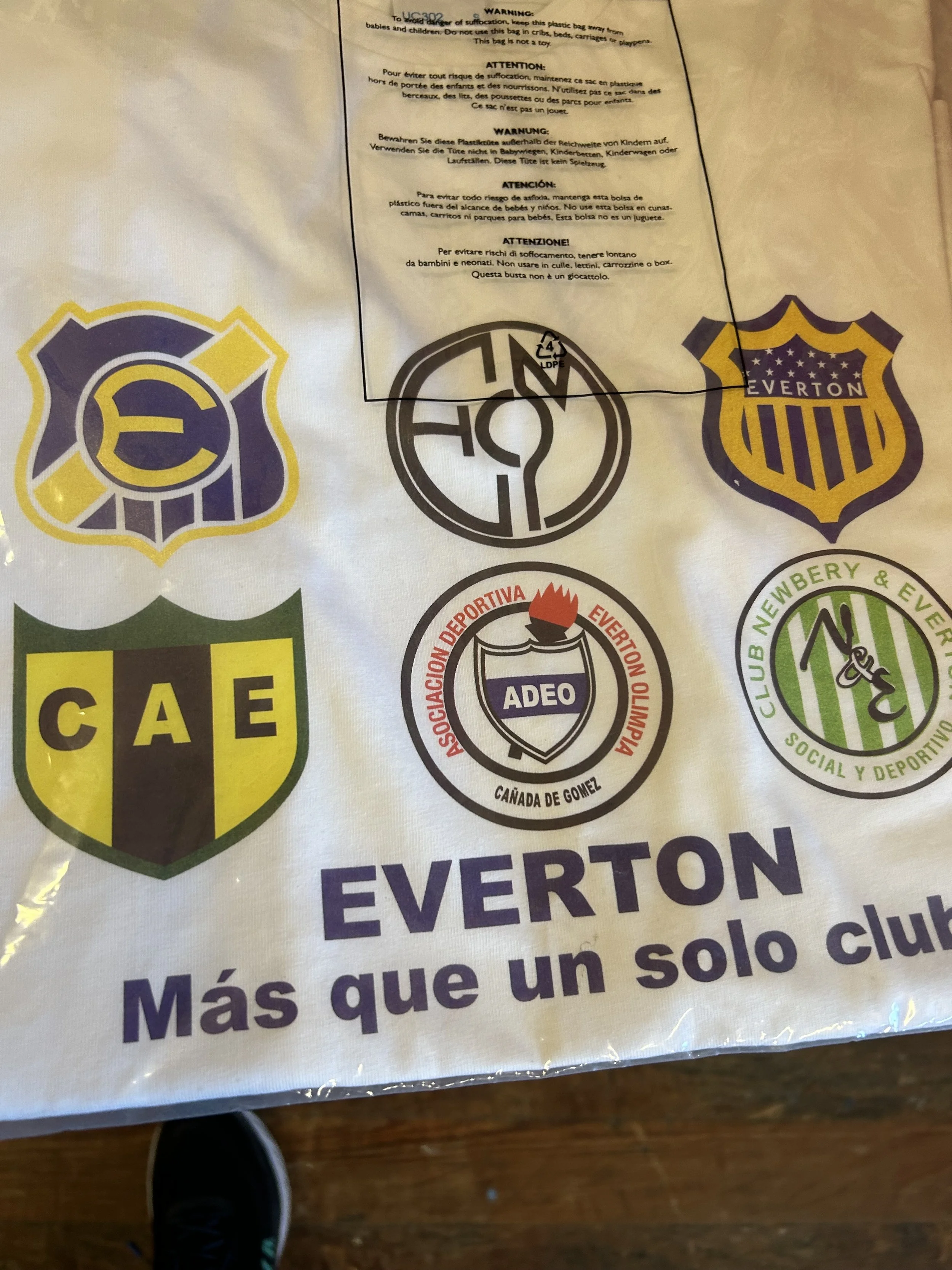 A large white cloth featuring various soccer club logos, including Everton, CAE, and others, with the phrase 'ÉVERTON Más que un solo club' written in Spanish.