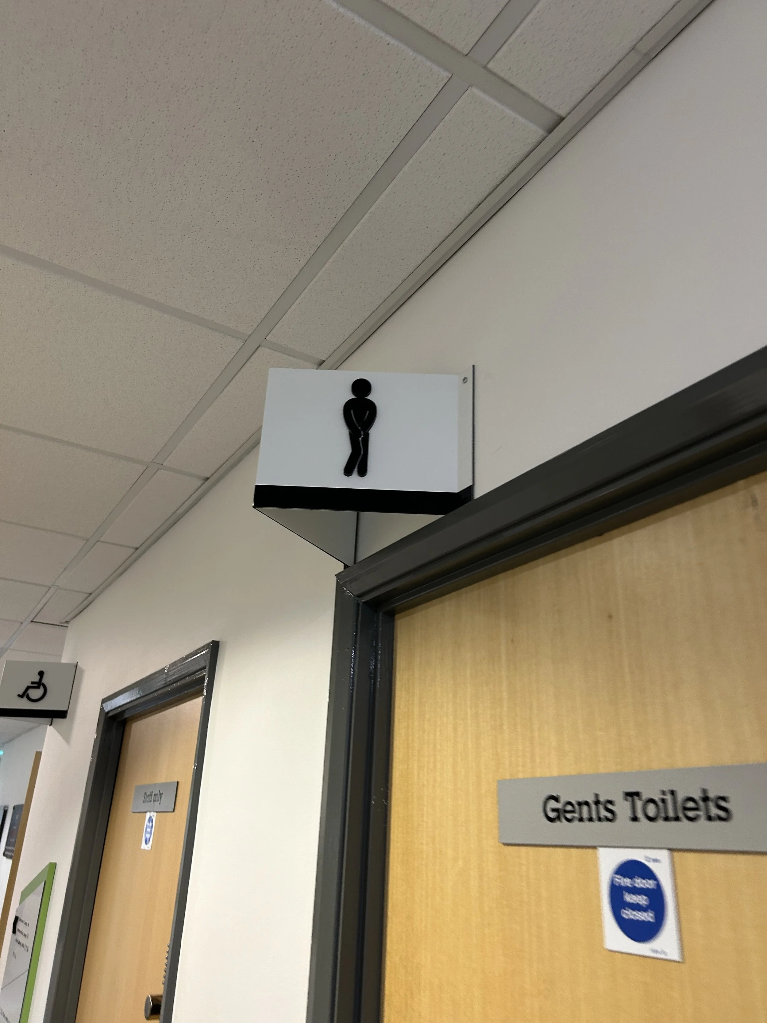 Sign above a door indicating men's restroom.
