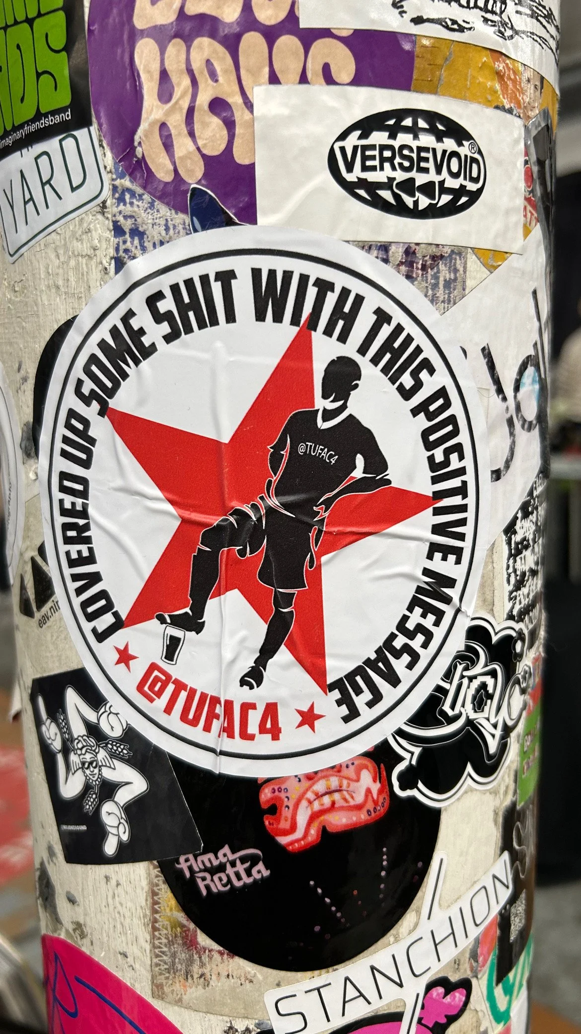 A circular sticker with a black silhouette of a person, a red star background, and the text "COVERED UP SOME SHIT WITH THIS POSITIVE MESSAGE" around it. The sticker also has the social media handle @TUFAC4.