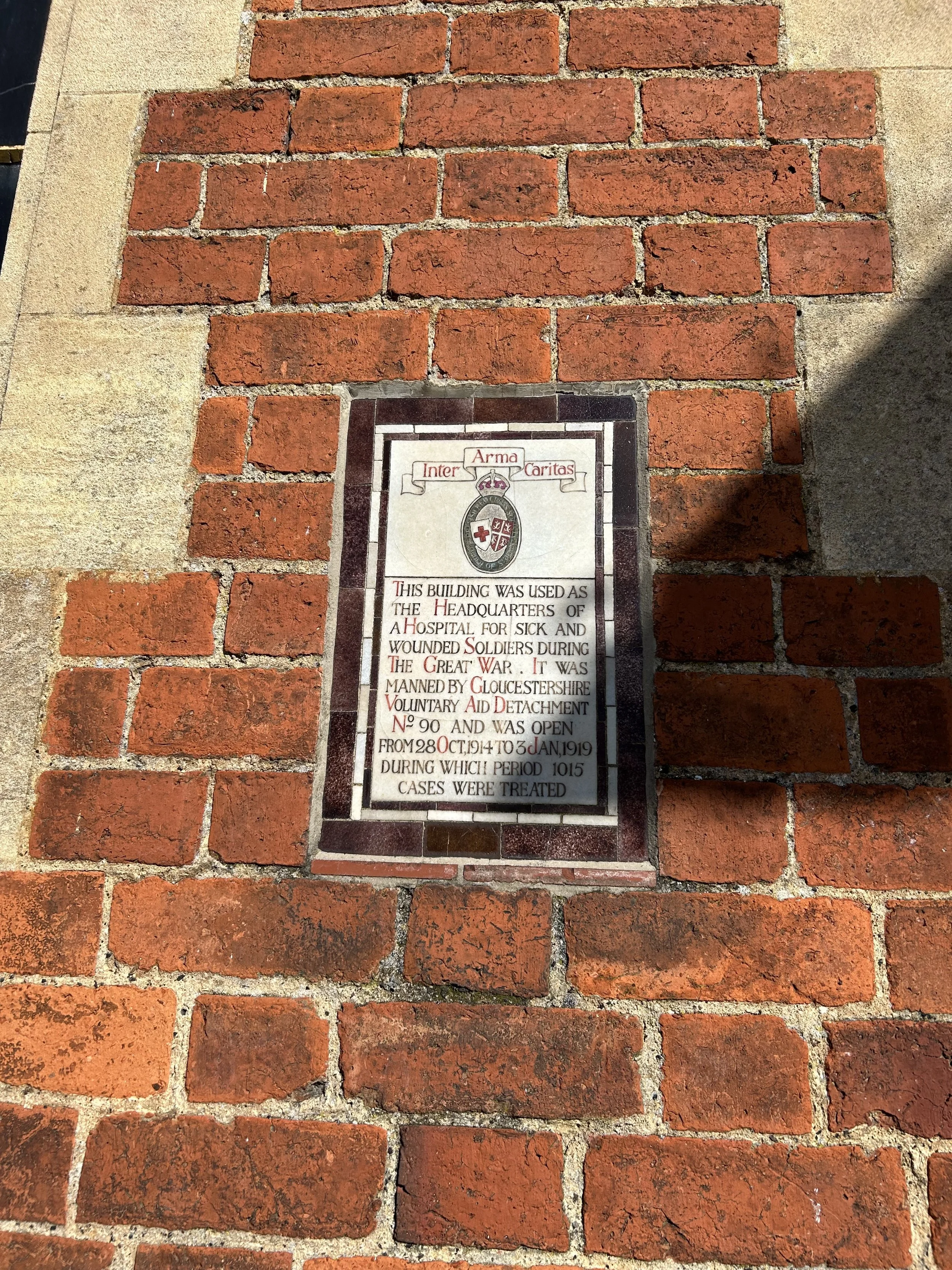 Historical plaque on brick wall, describing the use of the building as a hospital for sick and wounded soldiers during the Great War, manned by Gloucestershire Voluntary Aid Detachment, open from October 28, 1914, to January 3, 1919.