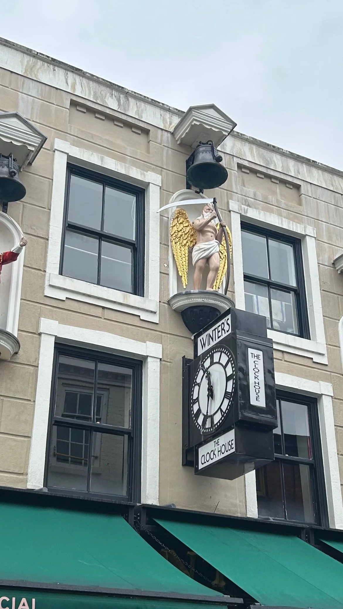 A building facade with a clock tower labeled 'Winter's The Clock House' and a statue of an angel with golden wings holding a scythe.