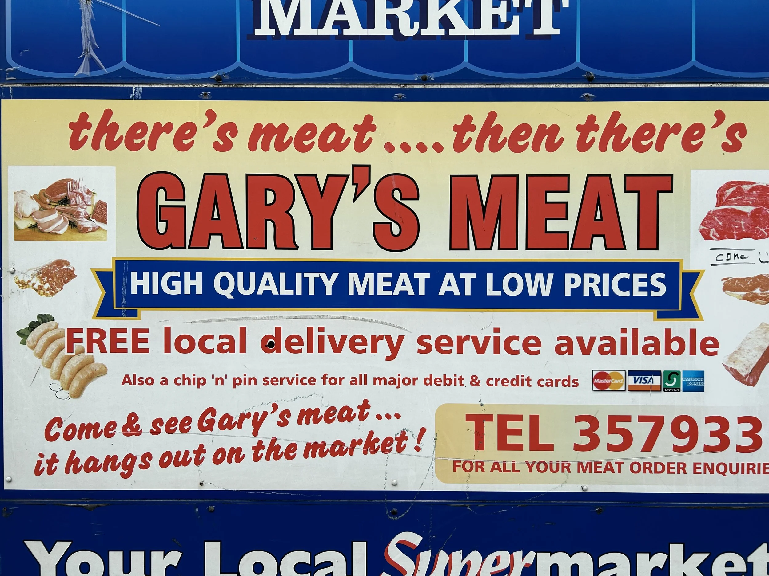 Sign advertising Gary's Meat, a local meat market offering high-quality meat at low prices, with free local delivery and chip 'n pin service, featuring images of various meats and the market's phone number.
