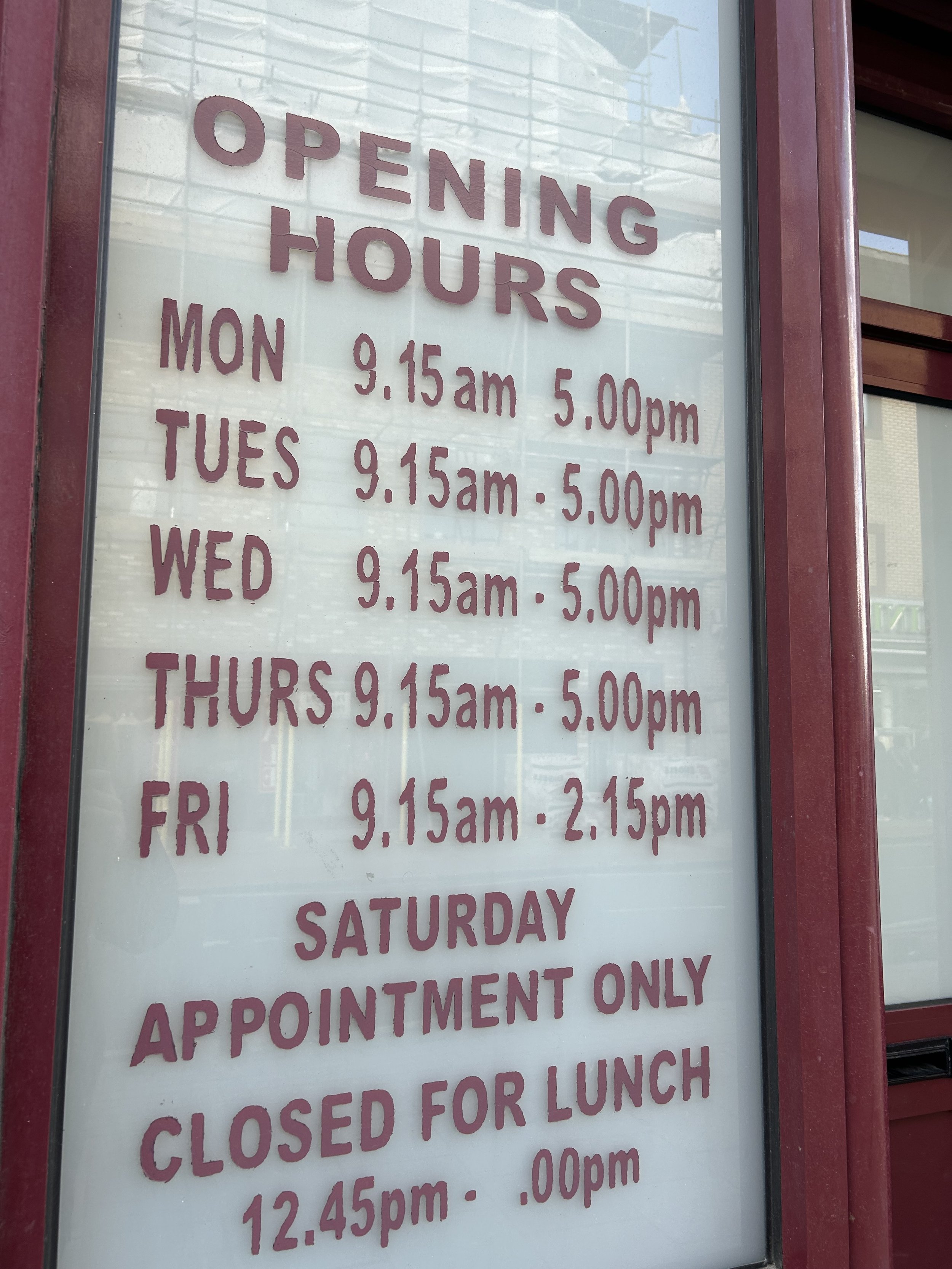 Sign displaying the daily opening hours of a business, with hours from 9:15 am to 5:00 pm Monday through Thursday, 9:15 am to 2:15 pm Friday, and appointments only on Saturday, closed for lunch from 12:45 pm to 1:00 pm.