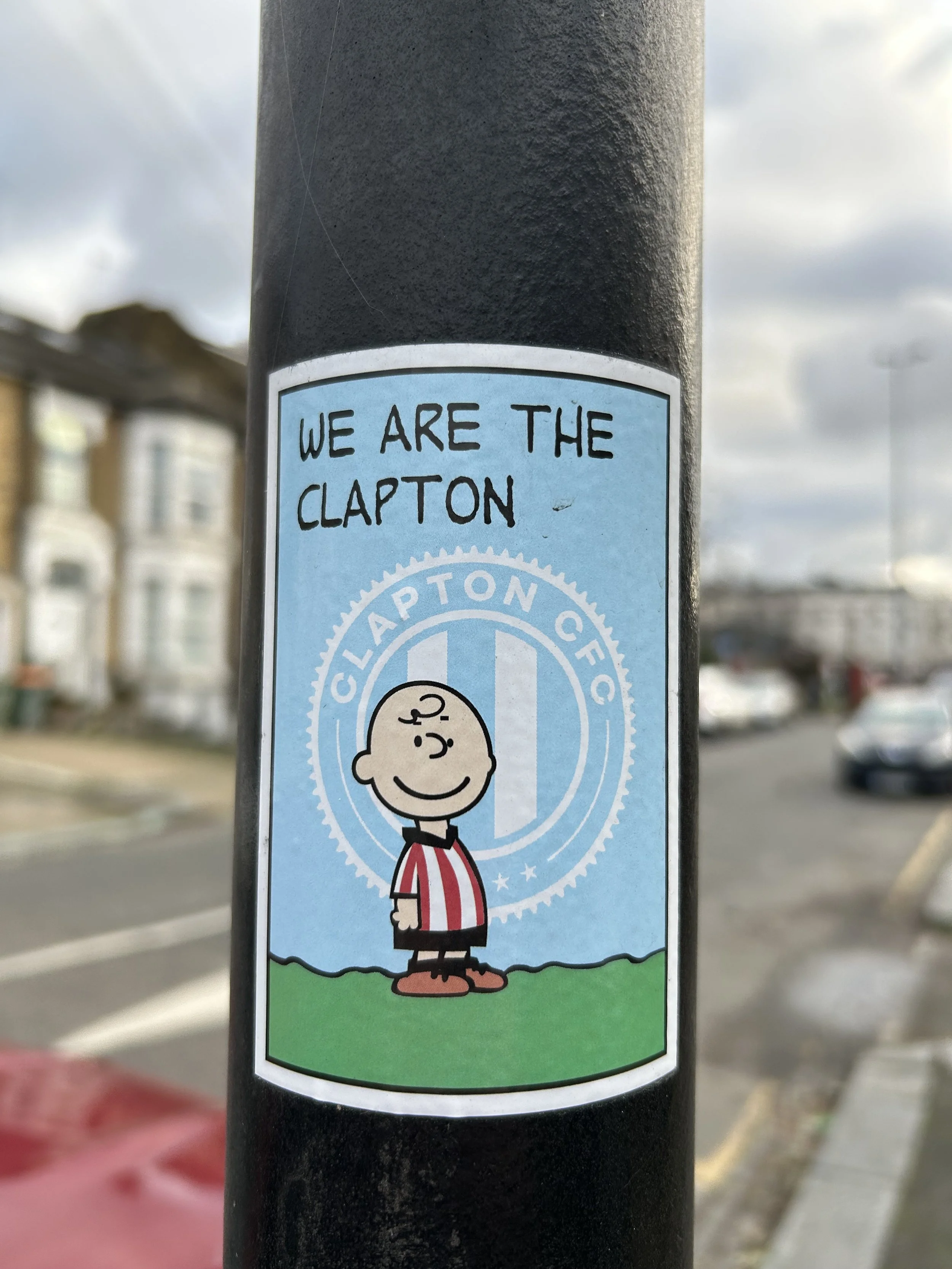 Sticker on a pole with Charlie Brown from Peanuts and the text "We are the Clapton" with a Clapton FC logo.