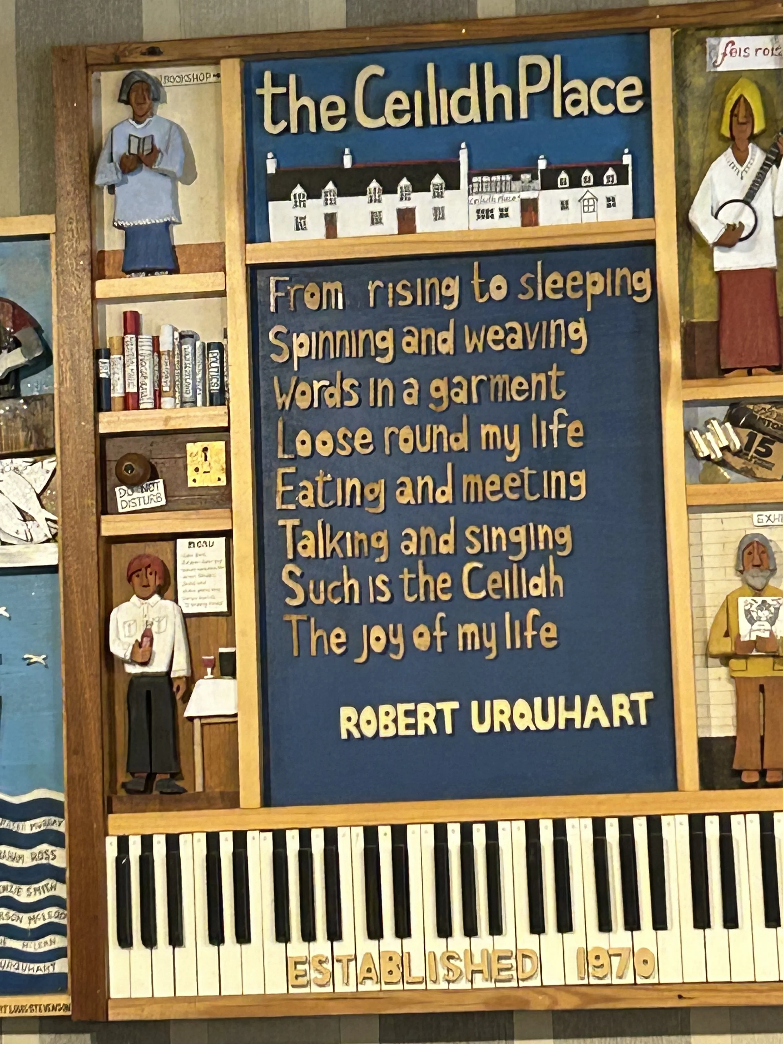 Decorative plaque with a poem about the Ceilidh Place, featuring illustrations of people, a piano keyboard at the bottom, and the words "ESTABLISHED 1970."