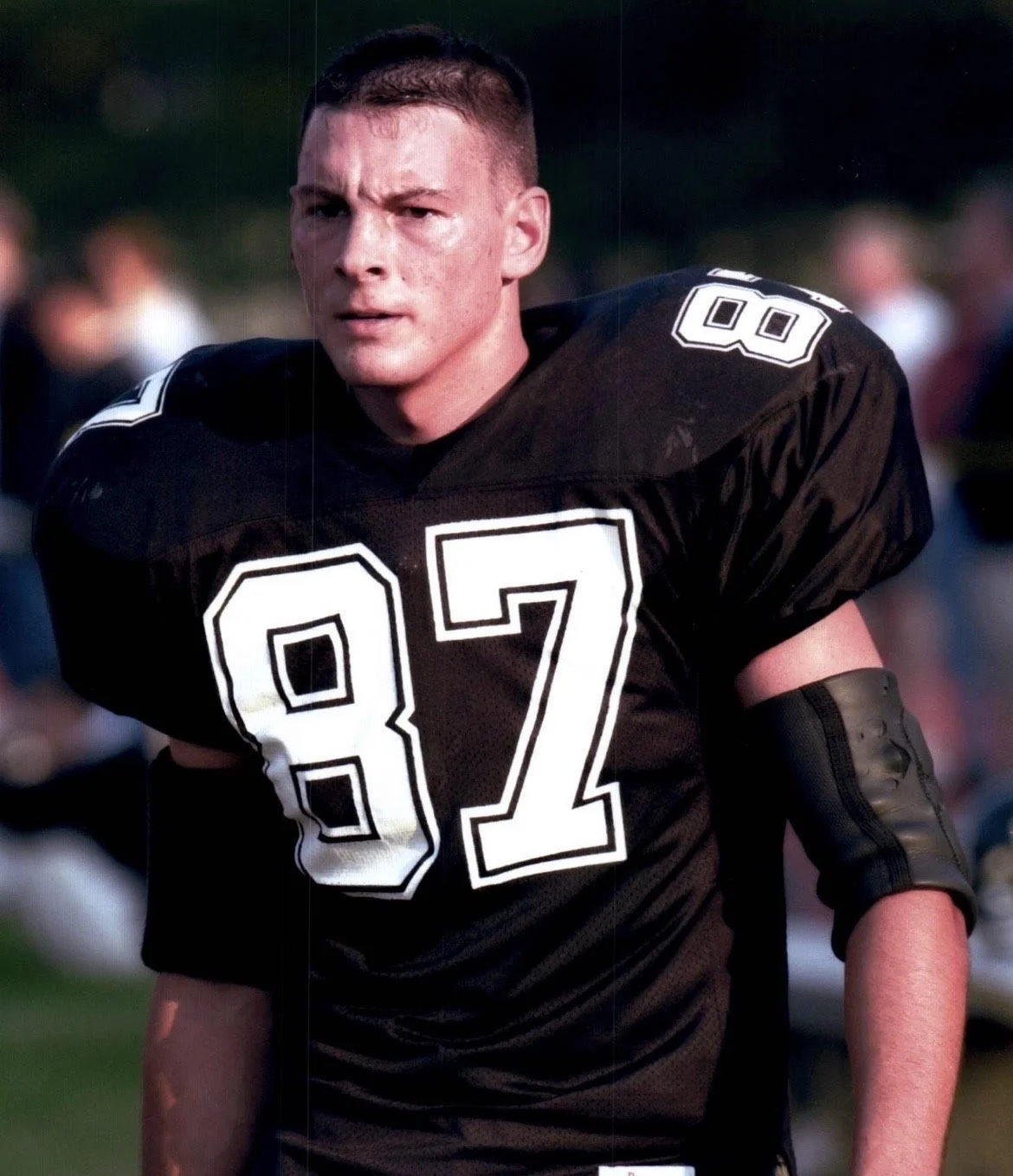 Young male football player in black uniform with the number 82