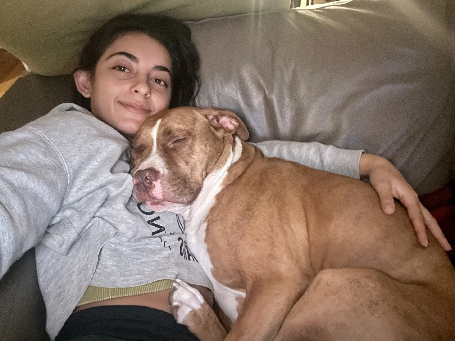 Snuggling with a dog, sleeping peacefully.