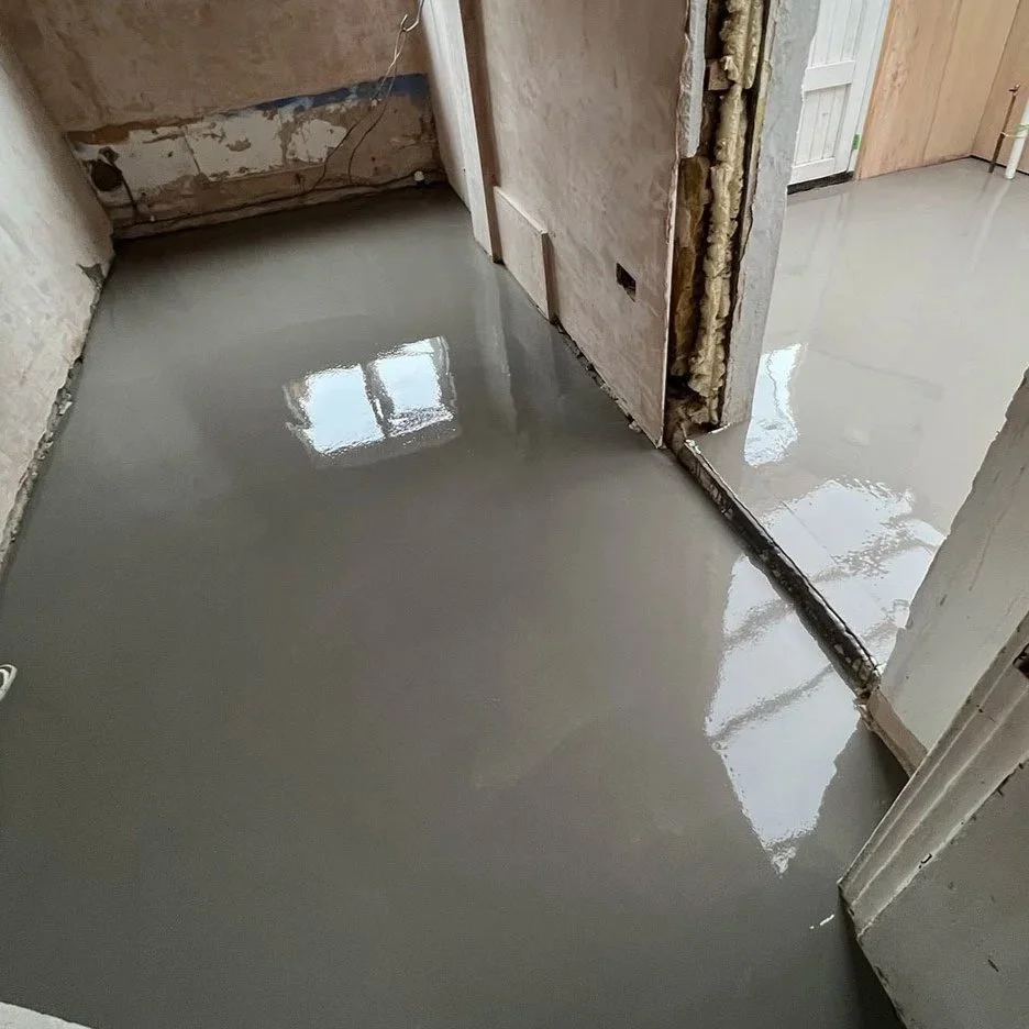 Freshly poured concrete floor in a partially renovated room.