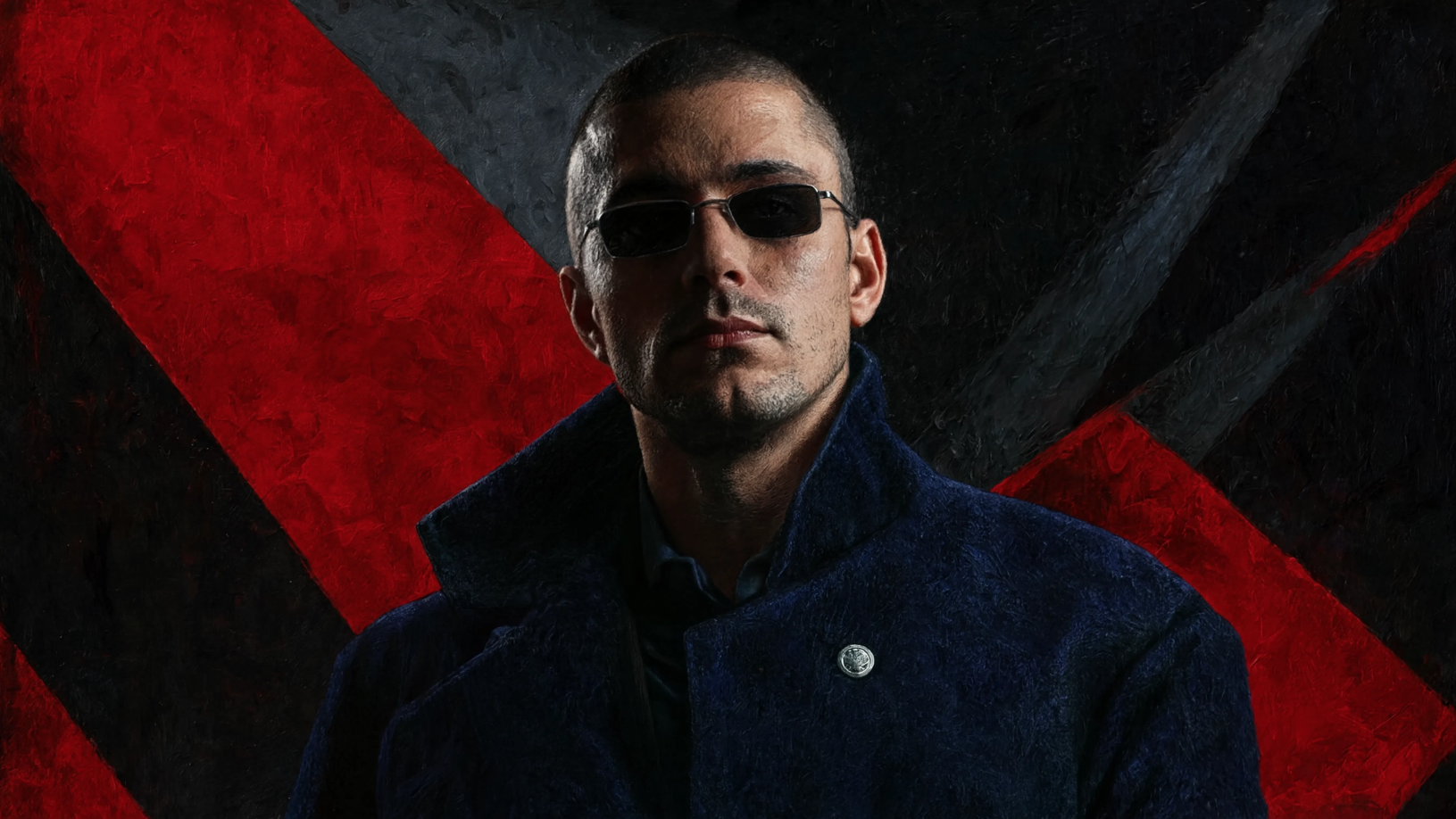 Robert Junqueira wearing sunglasses and a dark blue jacket with a high collar, standing in front of a background with diagonal red and black stripes.