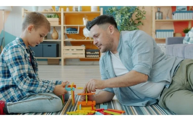 Parent working one-on-one with a child while building a learning activity at home