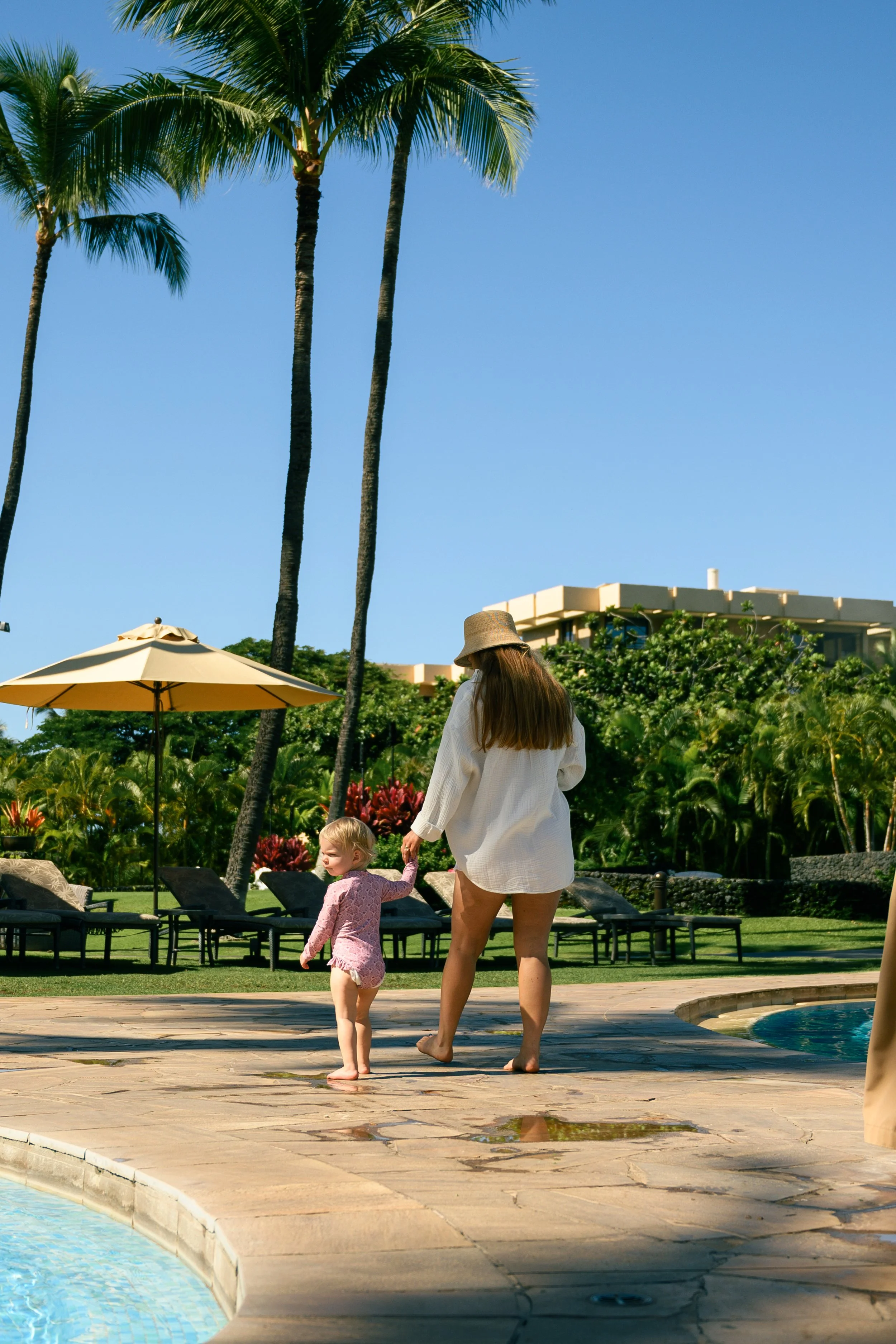 Professional Maui nanny walking with a young child at a resort