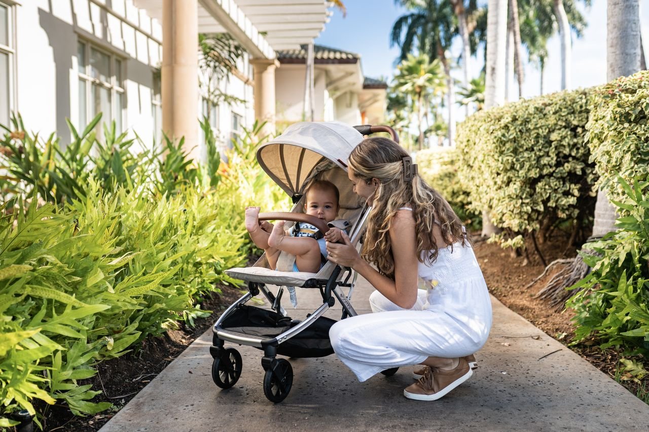 Professional Maui nanny caring for a baby in a stroller at a resort.