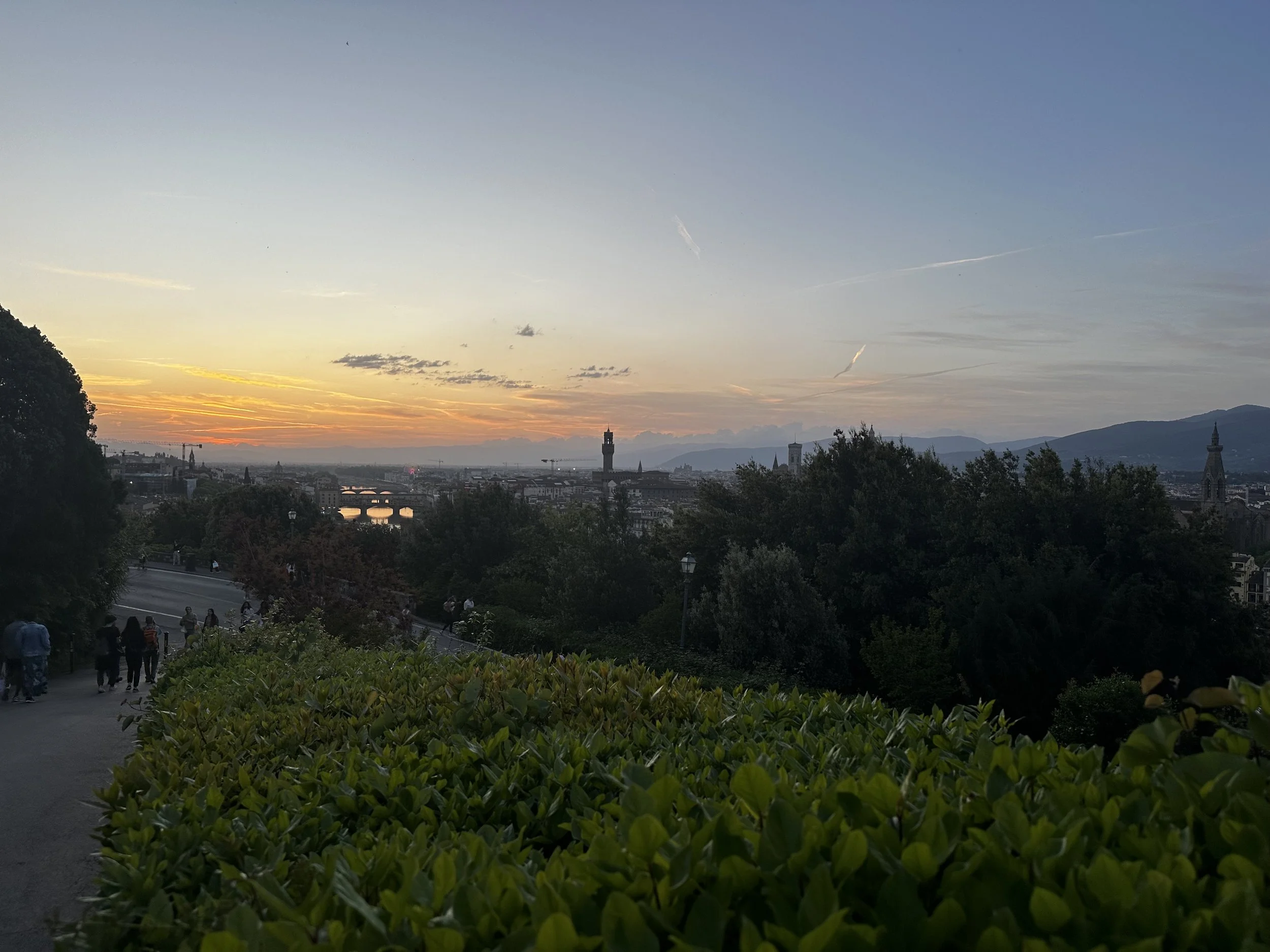 Sunset over Florence seen from Piazzale Michelangelo, with city rooftops and rolling hills.