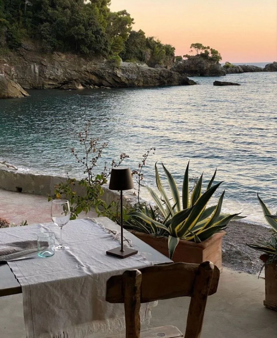 Authentic Italian table setting with a sea view and Mediterranean pine trees, ready for a slow food experience.