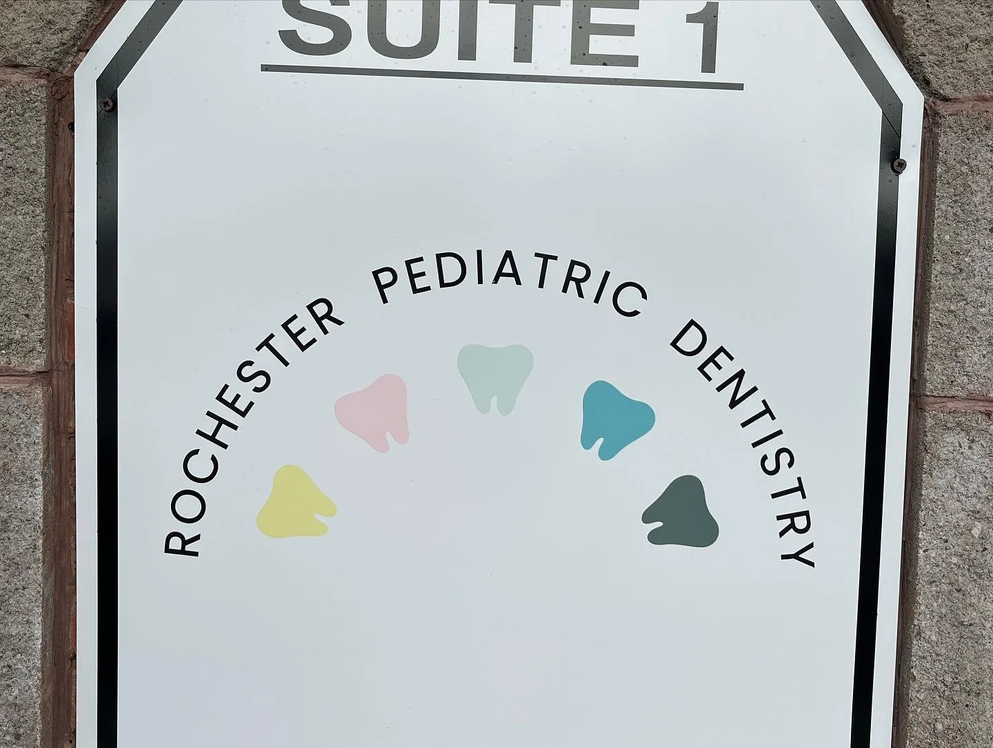 Sign for Rochester Pediatric Dentistry with colorful tooth icons.