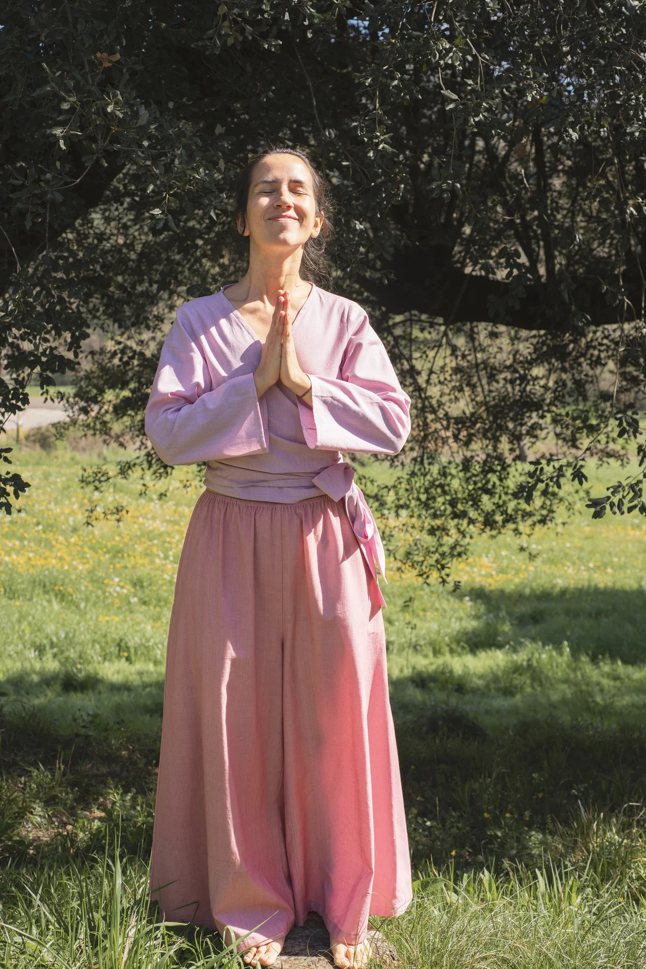 Mujer en la naturaleza vistiendo el Pantalón Orekan de pata ancha en color blanco, confeccionado en algodón orgánico y tintes naturales libres de tóxicos