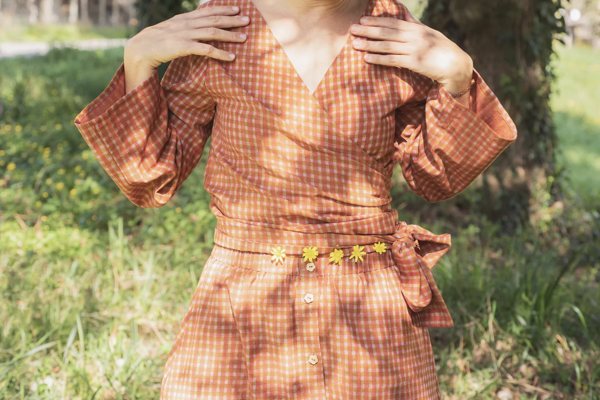 Mujer vistiendo blusa cruzada Kali de manga larga en algodón orgánico con estampado amanecer. Ropa teñida con tintes naturales sin tóxicos.