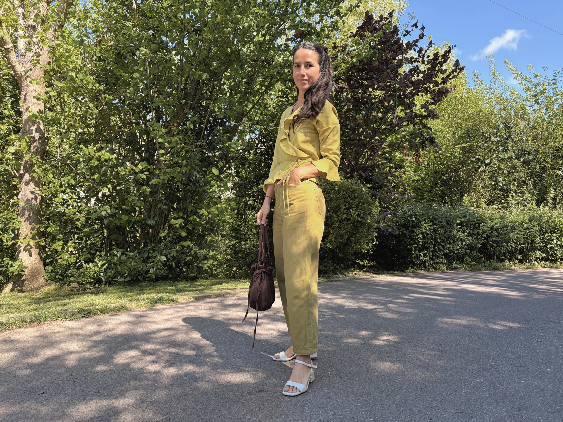 Mujer en la naturaleza vistiendo el Pantalón Luna de estilo denim. Pantalón de corte recto confeccionado en algodón orgánico natural con cierre de botones de coco. Moda consciente y sostenible.