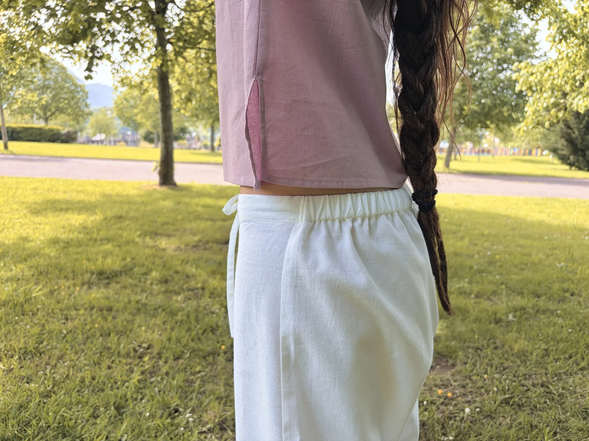 Mujer en postura de yoga vistiendo un pantalón ancho y fluido de algodón orgánico teñido con plantas naturales y hierbas medicinales ayurvastra