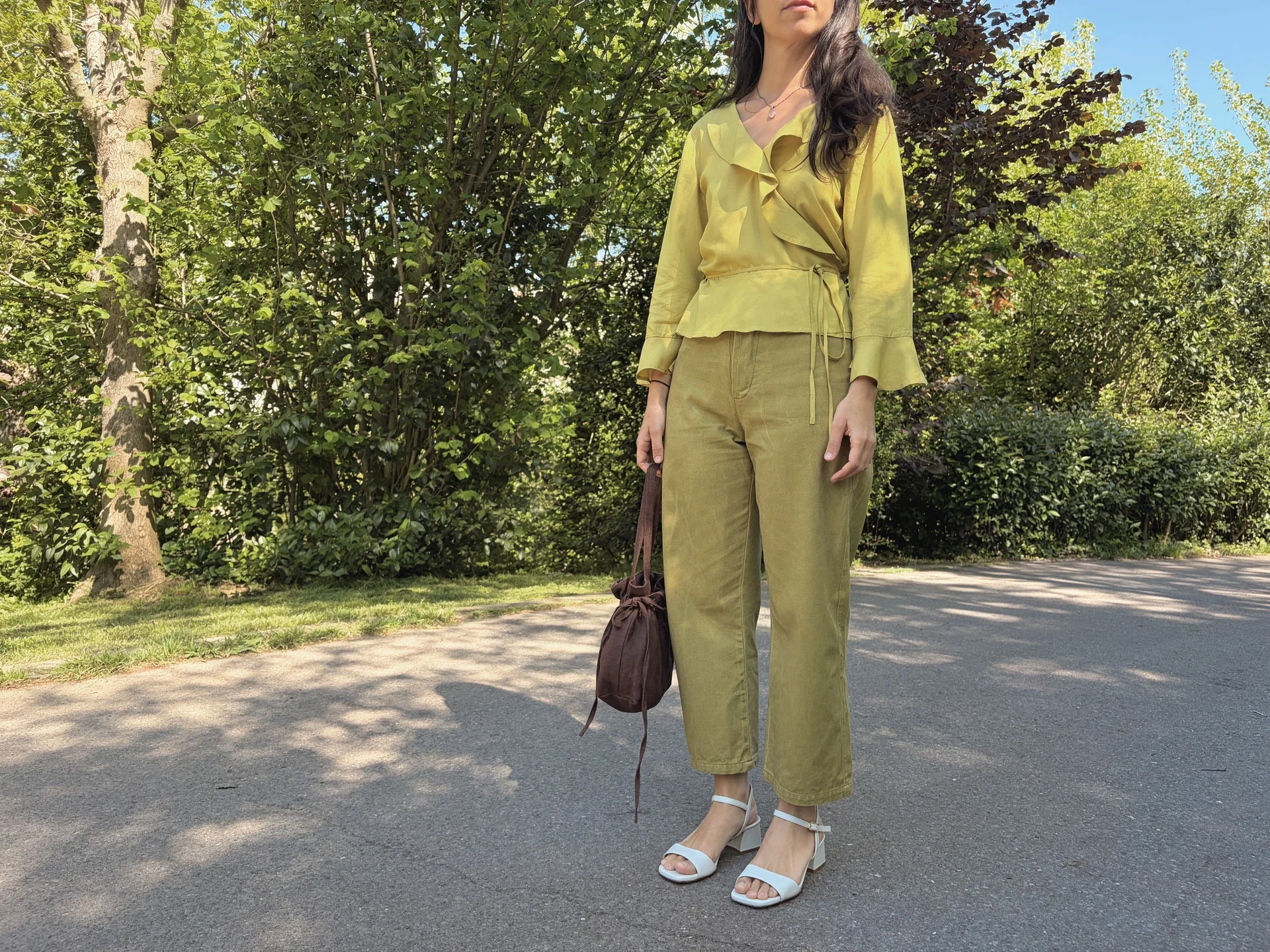 Mujer en la naturaleza vistiendo el Pantalón Luna de estilo denim. Pantalón de corte recto confeccionado en algodón orgánico natural con cierre de botones de coco. Moda consciente y sostenible.