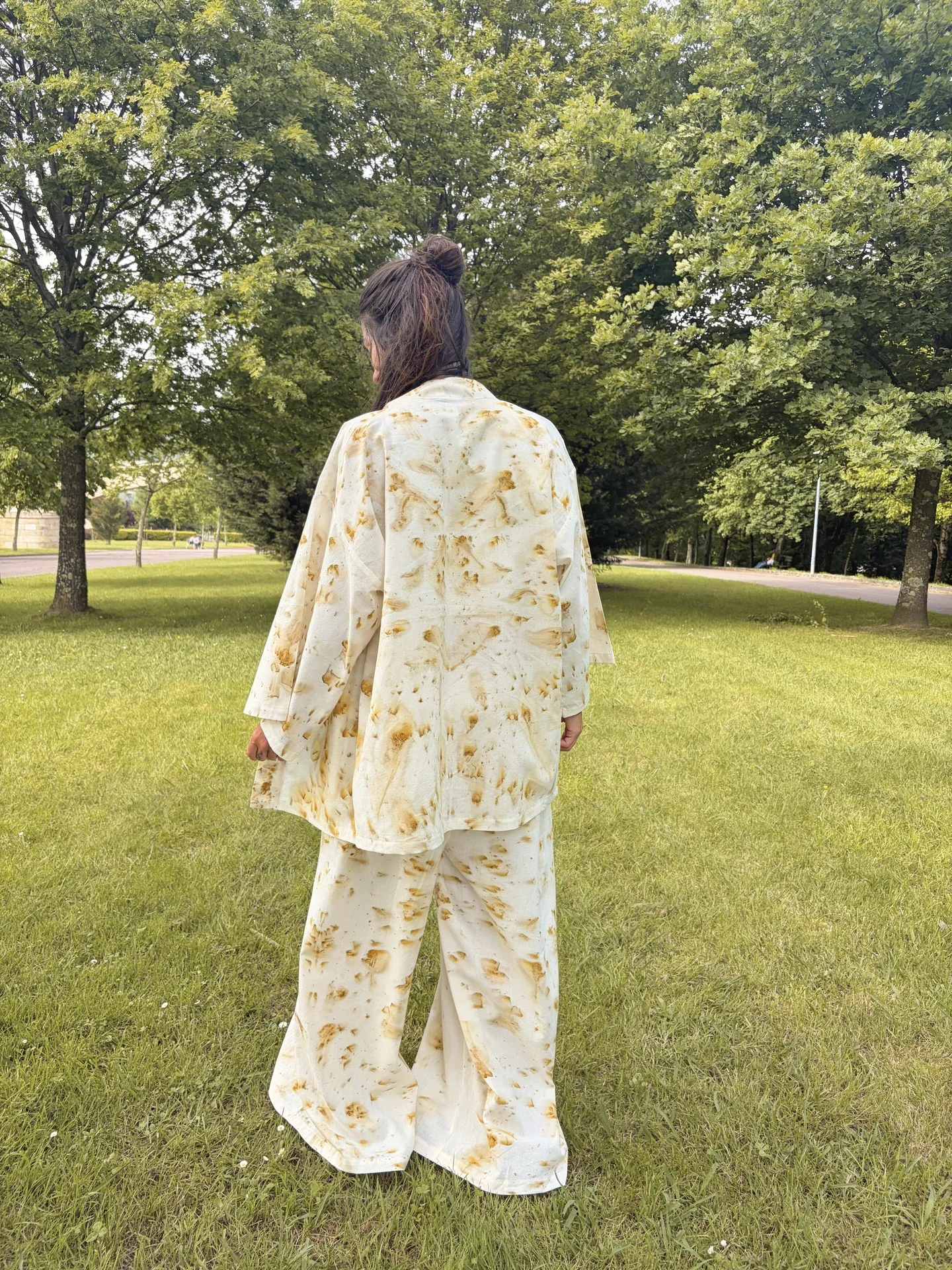 vistiendo un kimono de algodón orgánico claro con estampado botánico de flores doradas de Pericón